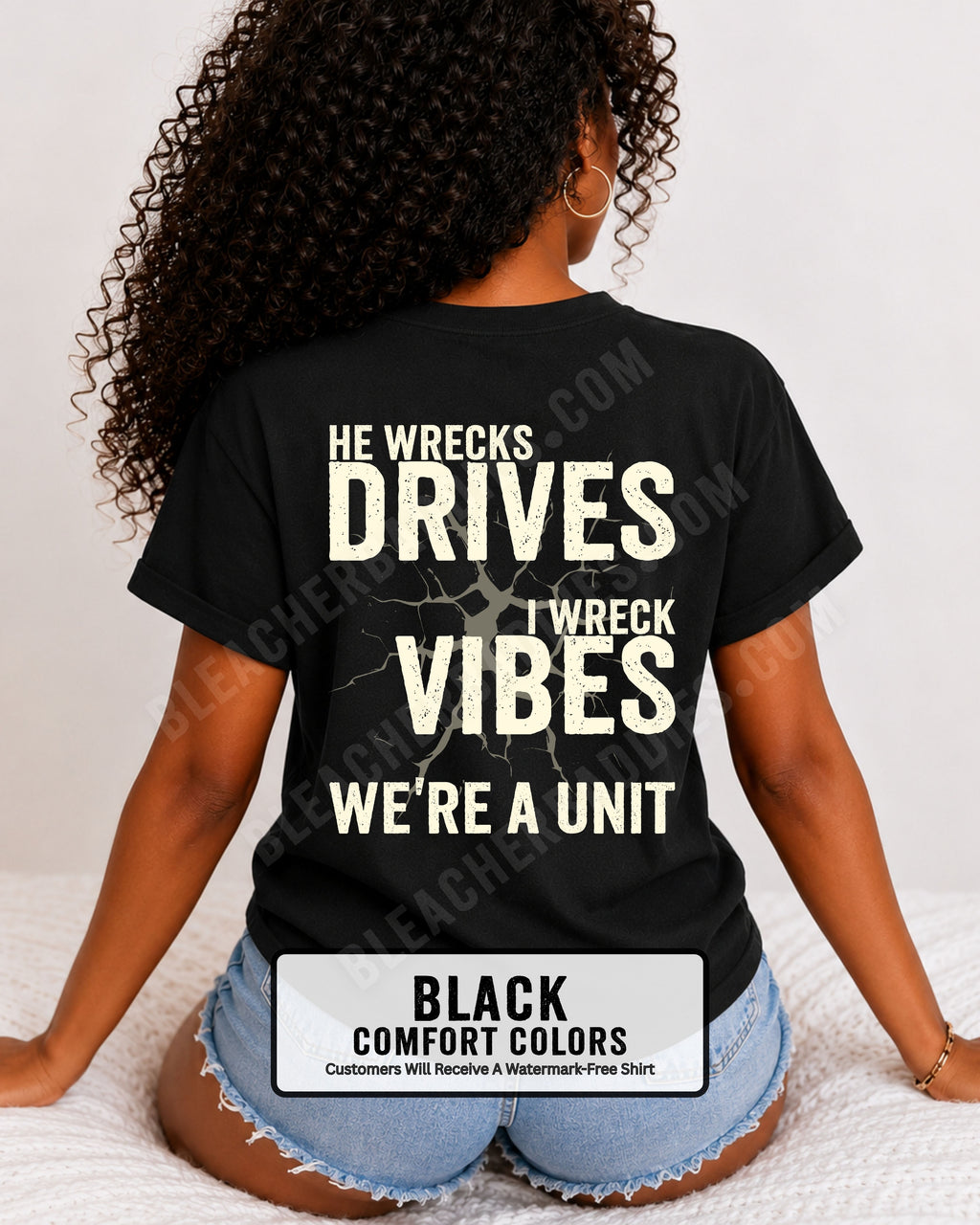 Woman wearing a black Comfort Colors t-shirt shown from the back featuring a large distressed cream graphic that reads “He Wrecks Drives I Wreck Vibes We’re a Unit.” Football Mom Shirt