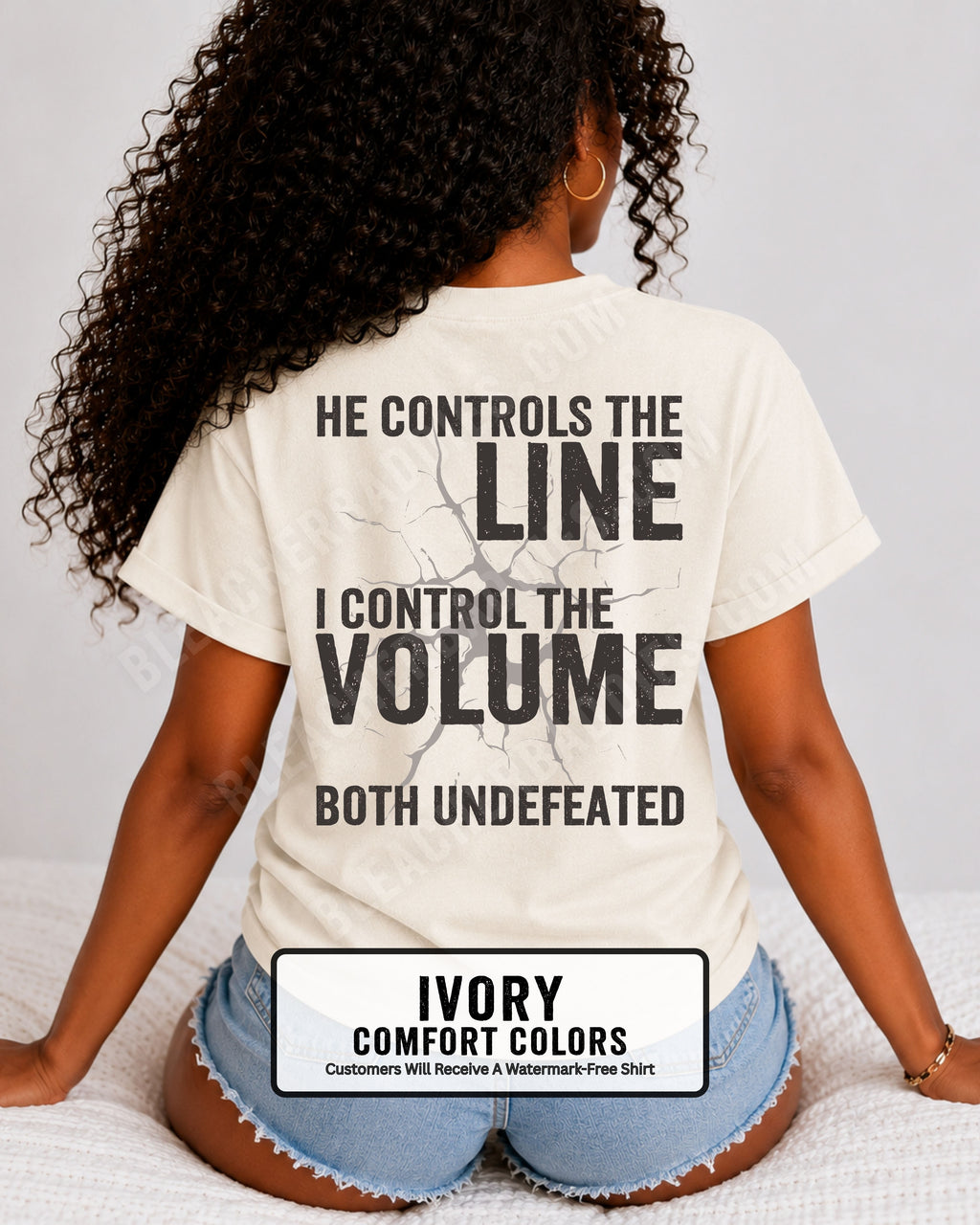 Back view of woman wearing ivory Comfort Colors football mom game day shirt featuring “He Controls the Line I Control the Volume Both Undefeated” bold graphic design. Lineman Mom Shirt.