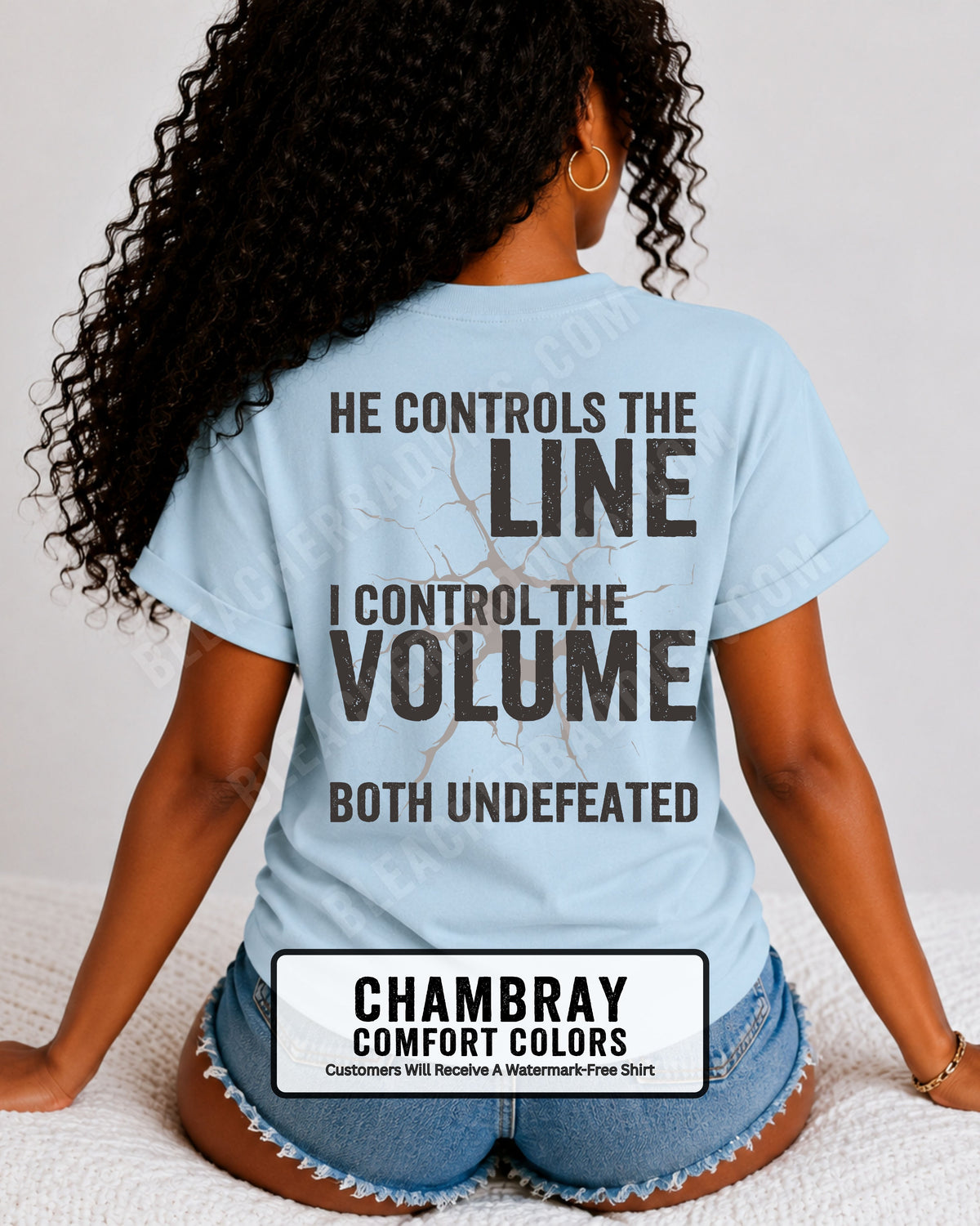 Back view of woman wearing chambray blue Comfort Colors football mom game day shirt featuring “He Controls the Line I Control the Volume Both Undefeated” bold graphic design