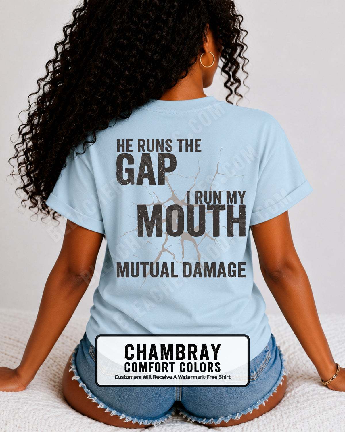 Back view of football mom wearing chambray blue Comfort Colors game day shirt with “He Runs the Gap I Run My Mouth Mutual Damage” graphic design
