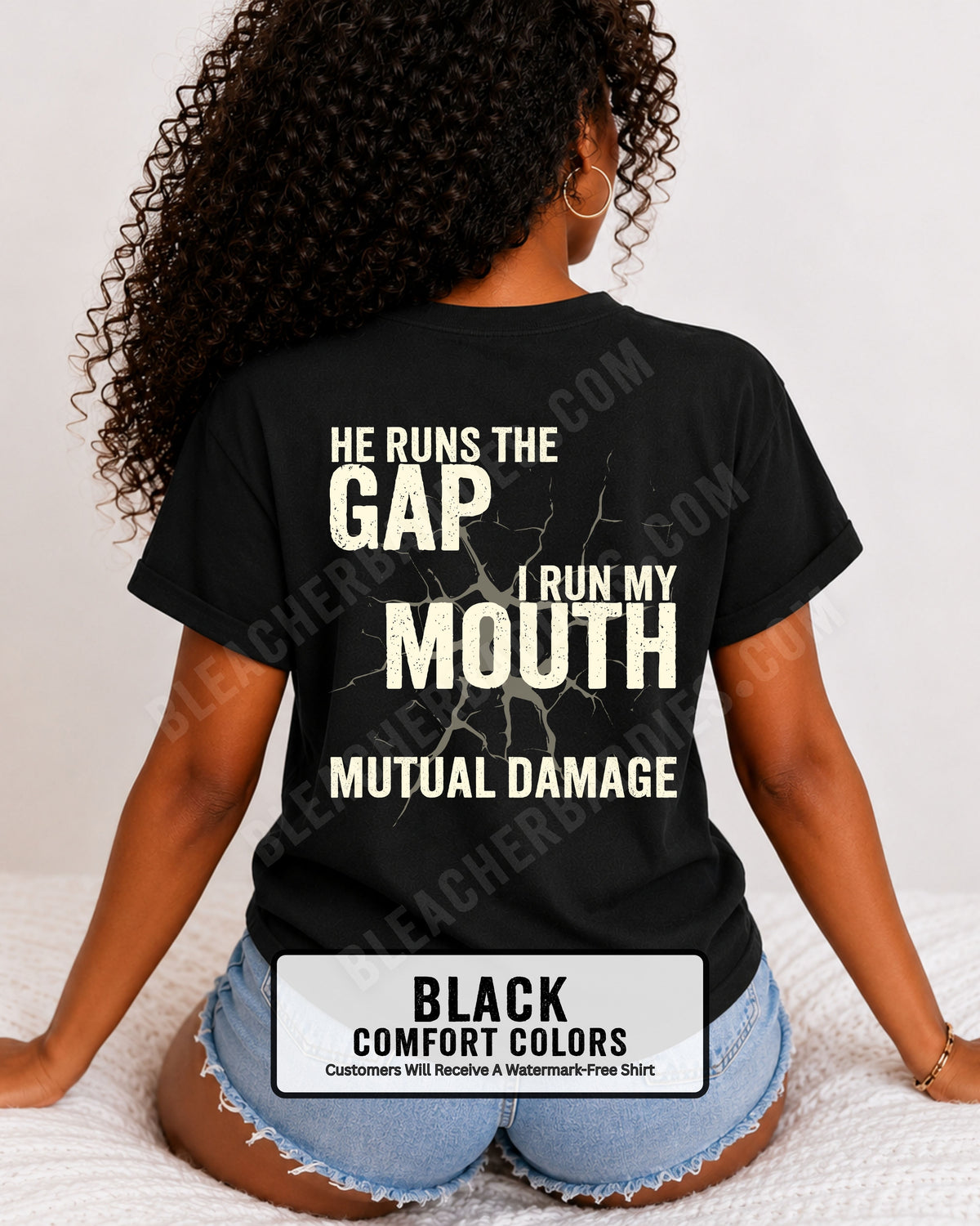 Back view of football mom wearing black Comfort Colors game day shirt with “He Runs the Gap I Run My Mouth Mutual Damage” graphic design