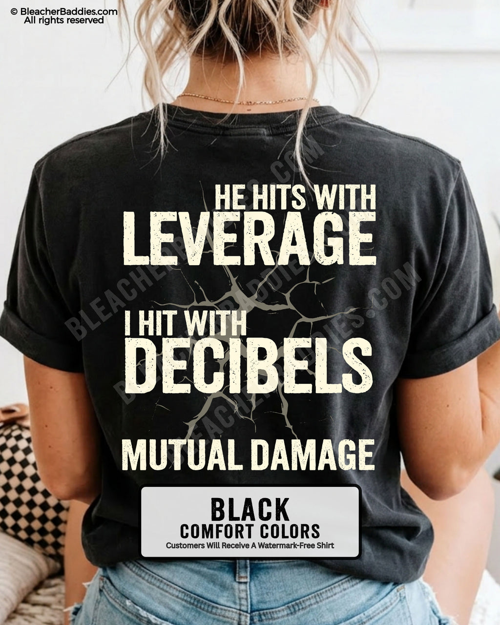 Back view of a black Comfort Colors football mom t-shirt featuring the "He Hits with Leverage, I Hit with Decibels" graphic and "Mutual Damage" printed in a distressed game day design.