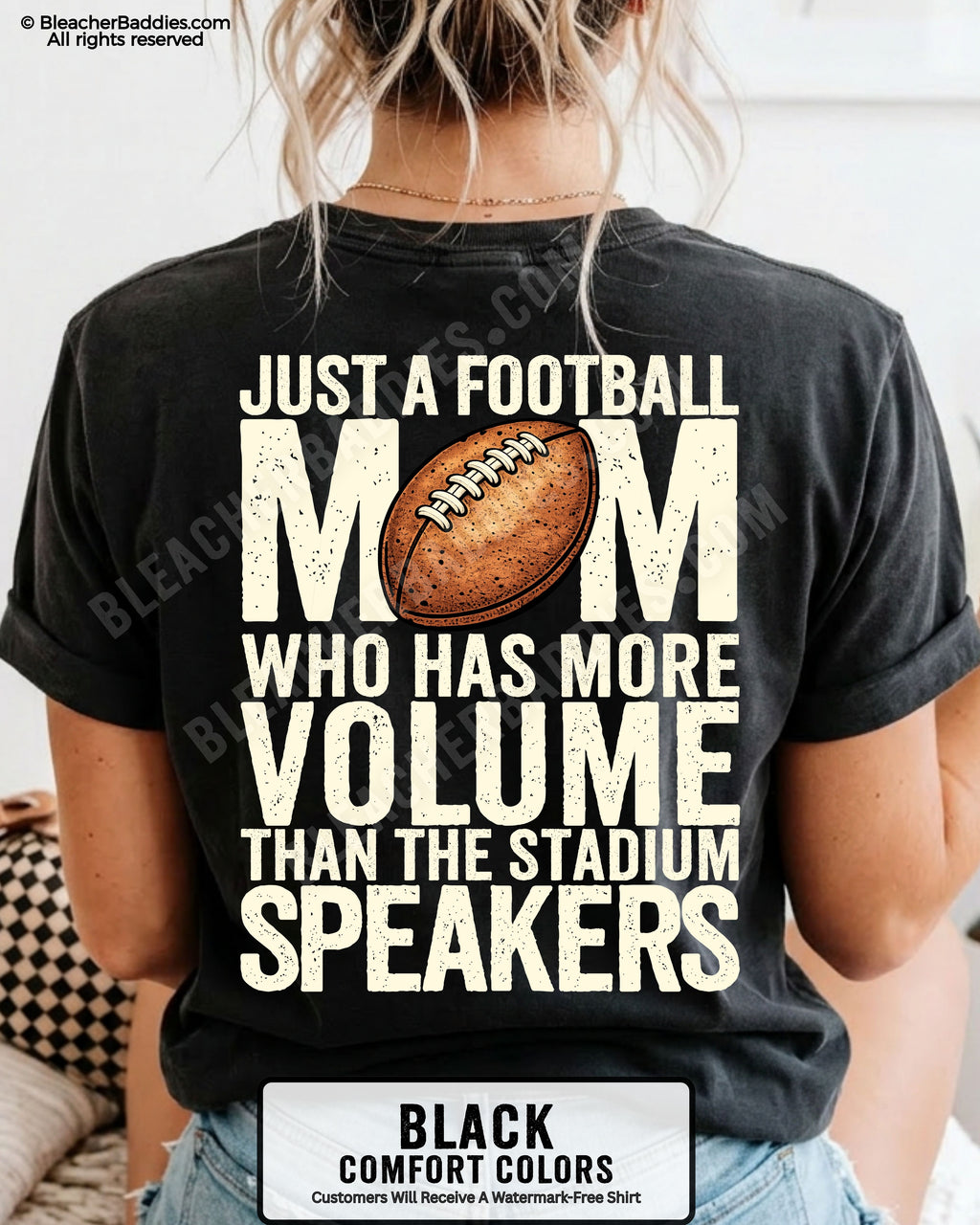 Black Comfort Colors t-shirt worn by woman showing back graphic reading “Just a football mom who has more volume than the stadium speakers” with football illustration