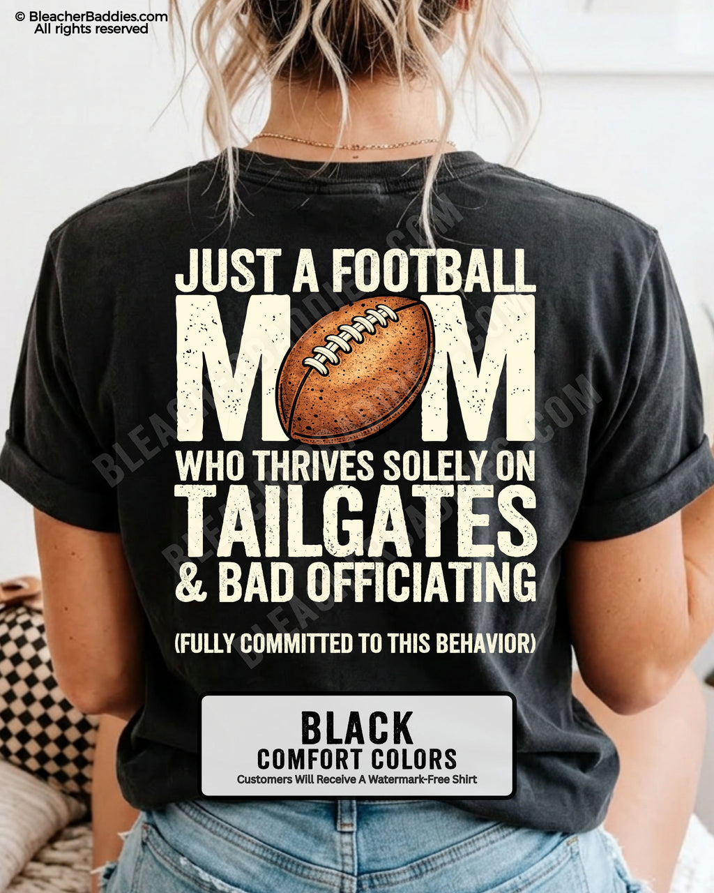Football mom game day shirt worn by a model on a black Comfort Colors tee, featuring a back graphic that says, “Just a football mom who thrives solely on tailgates & bad officiating (fully committed to this behavior).”