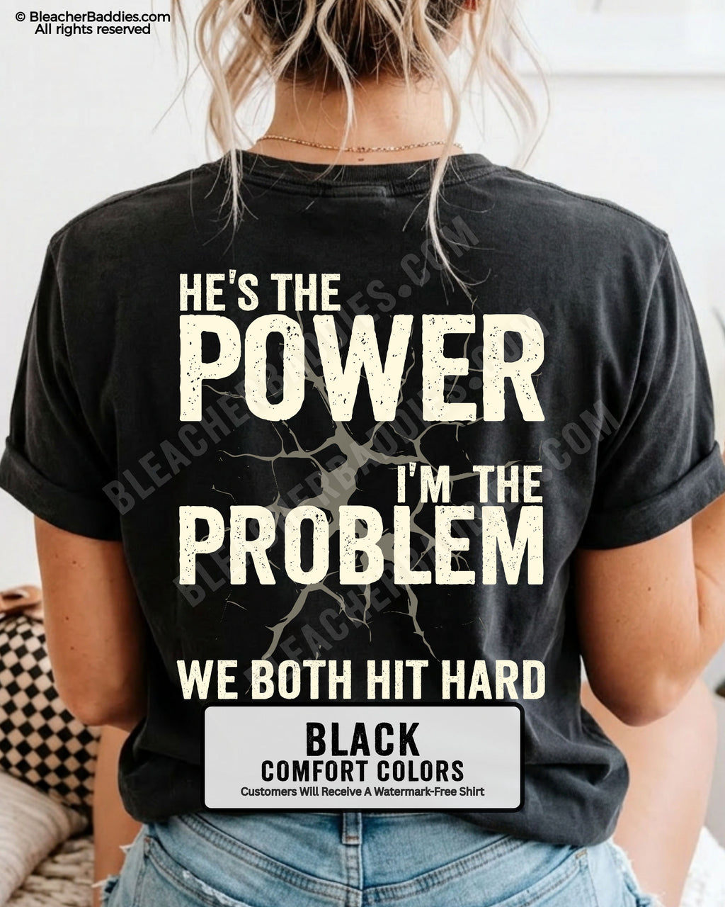 Back view of black Comfort Colors football mom game day shirt reading “He’s the Power I’m the Problem We Both Hit Hard,” close-up fit on woman wearing denim shorts