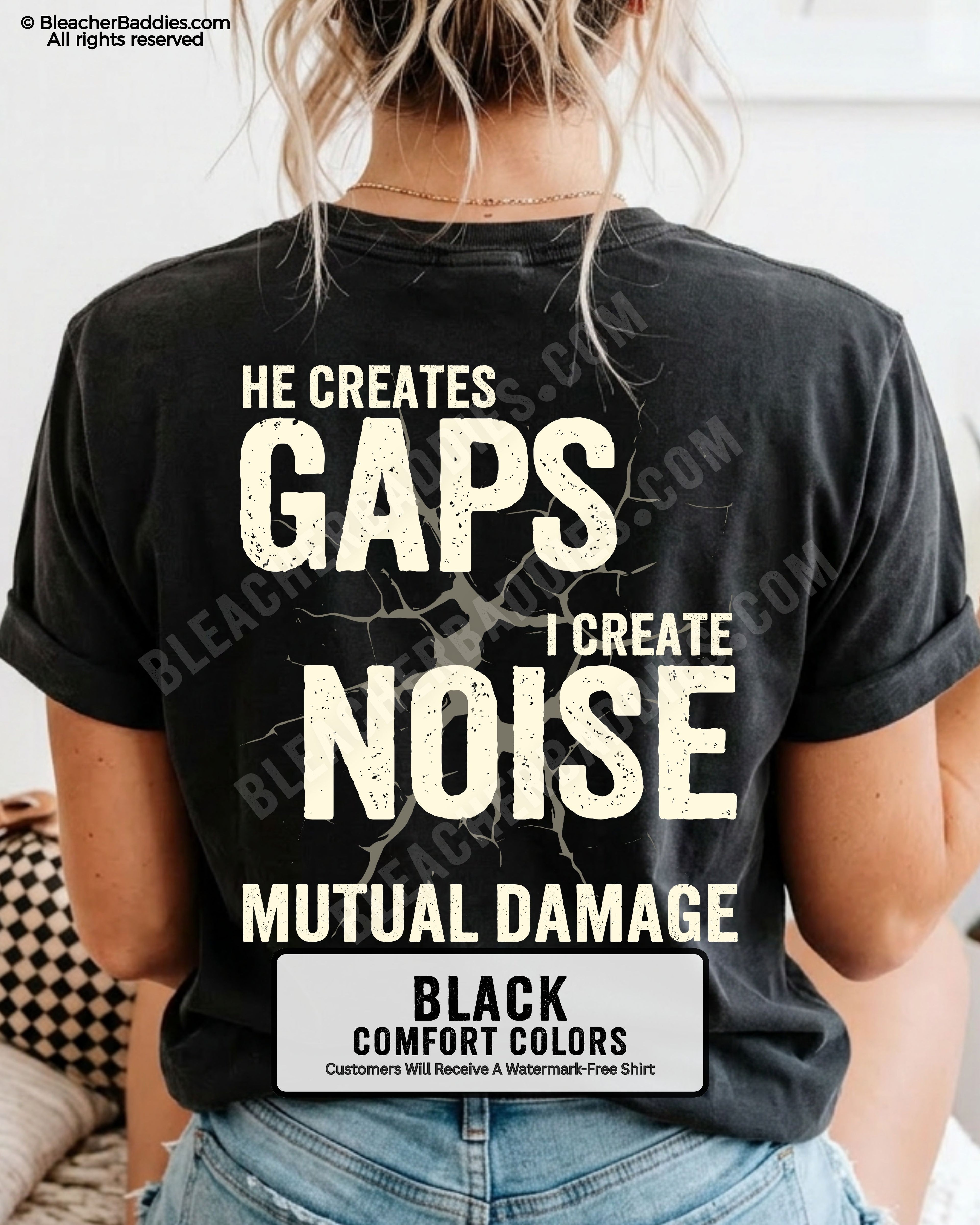 Woman wearing BLACK Comfort Colors football mom game day shirt with back design that reads “He creates gaps I create noise mutual damage” in distressed CREAM text with cracked graphic and chambray color label shown