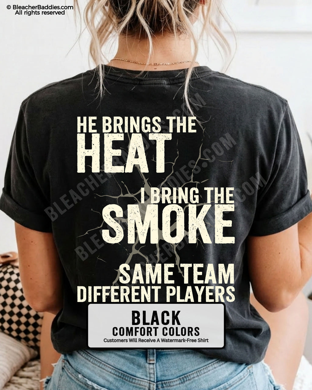 Close-up of BLACK COMFORT COLORS FOOTBALL MOM t-shirt back print showing distressed text “He Brings the Heat I Bring the Smoke Same Team Different Players” with cracked design detail