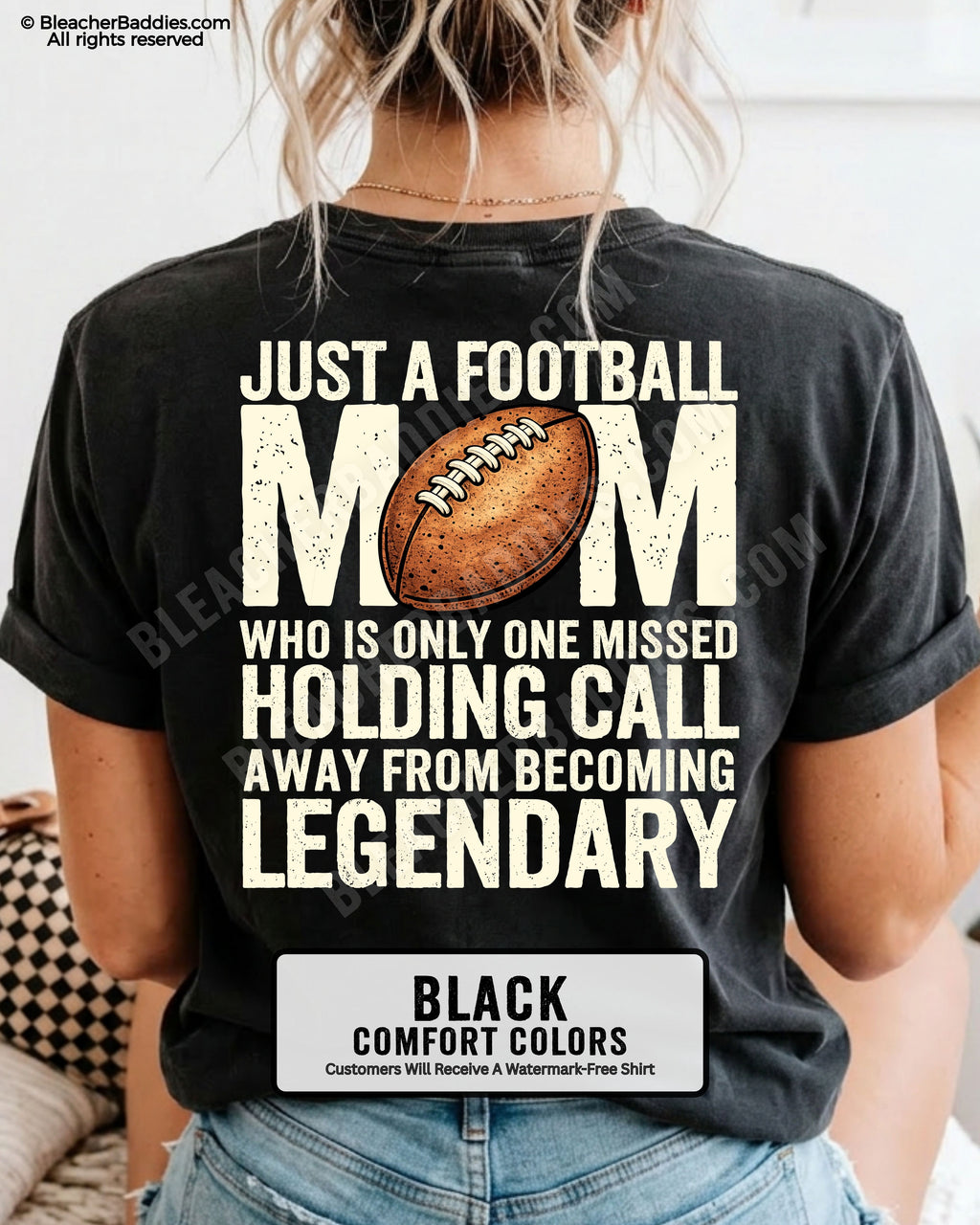 Woman wearing black Comfort Colors t-shirt showing back graphic reading “Just a football mom who is only one missed holding call away from becoming legendary” with football design