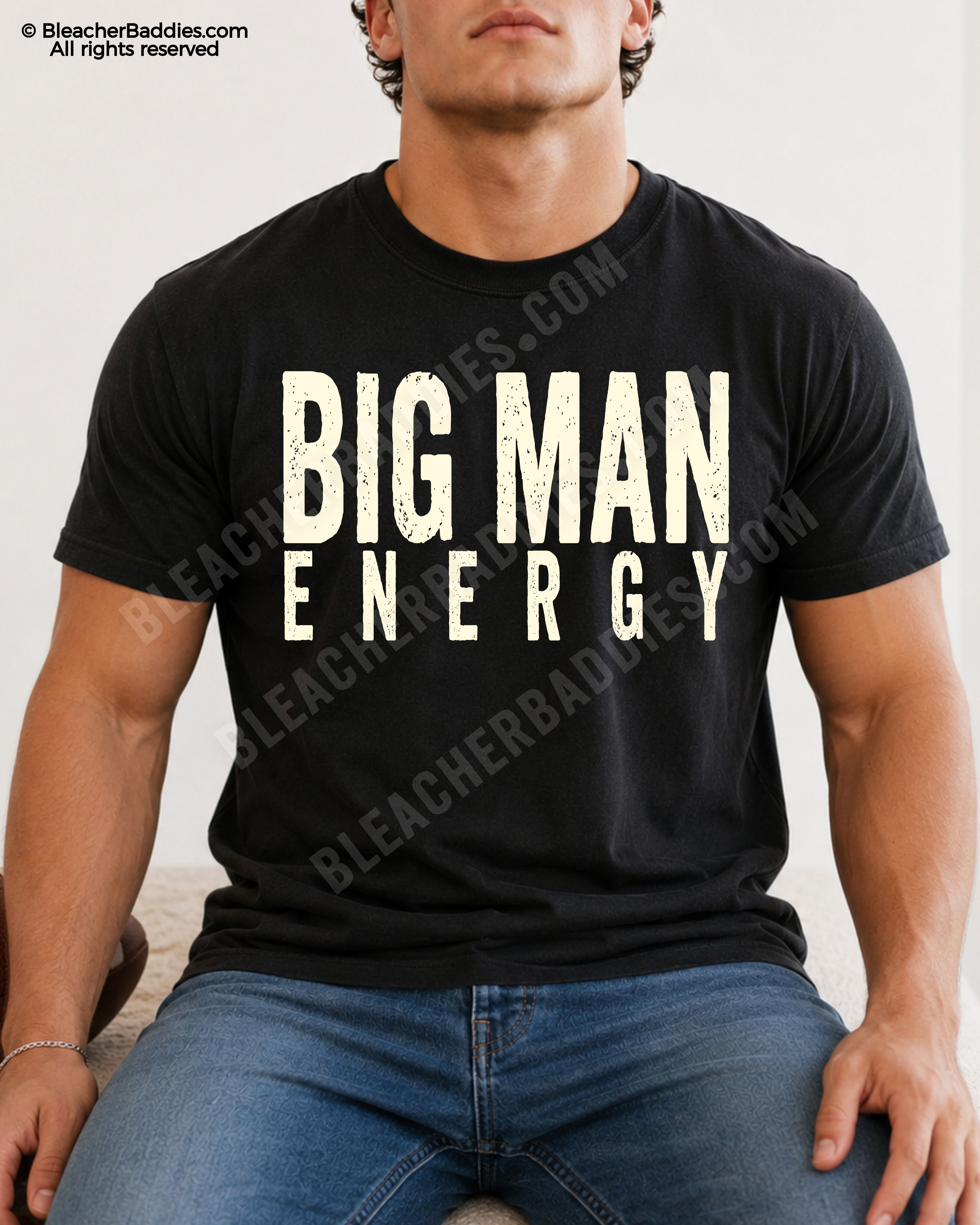 Male football player model wearing a black Comfort Colors Big Man Energy shirt with distressed cream lettering while sitting indoors. Funny offensive line inspired game day shirt for linemen and big athletes.