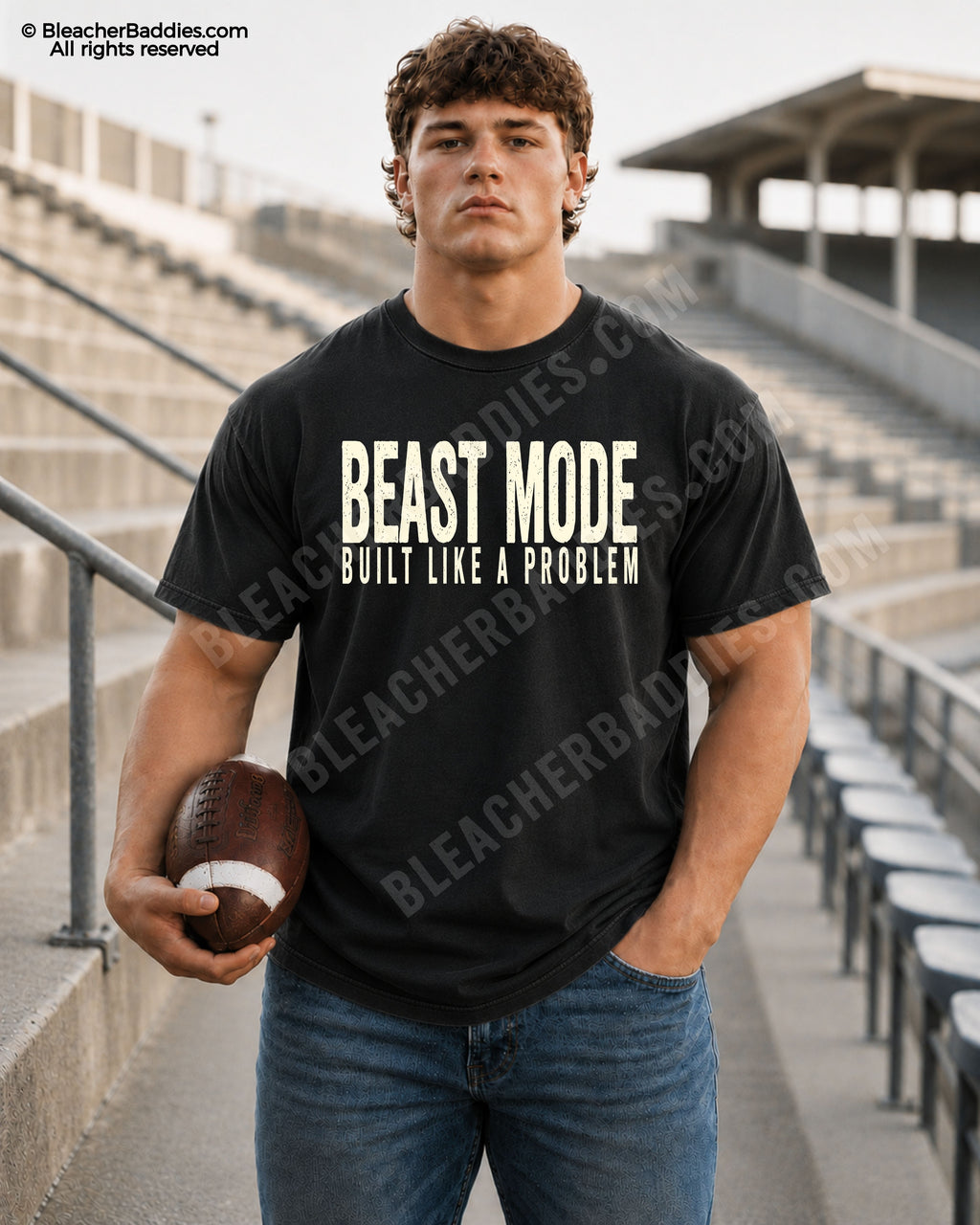 Football player model standing in stadium bleachers wearing a black oversized game day shirt featuring distressed “BEAST MODE BUILT LIKE A PROBLEM” typography with football in hand.