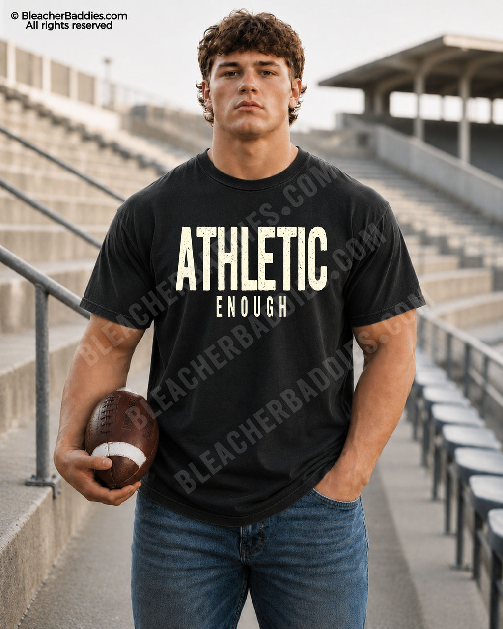 Football player standing in stadium wearing a BLACK Comfort Colors “Athletic Enough” game day shirt with distressed CREAM lettering and athletic football aesthetic.