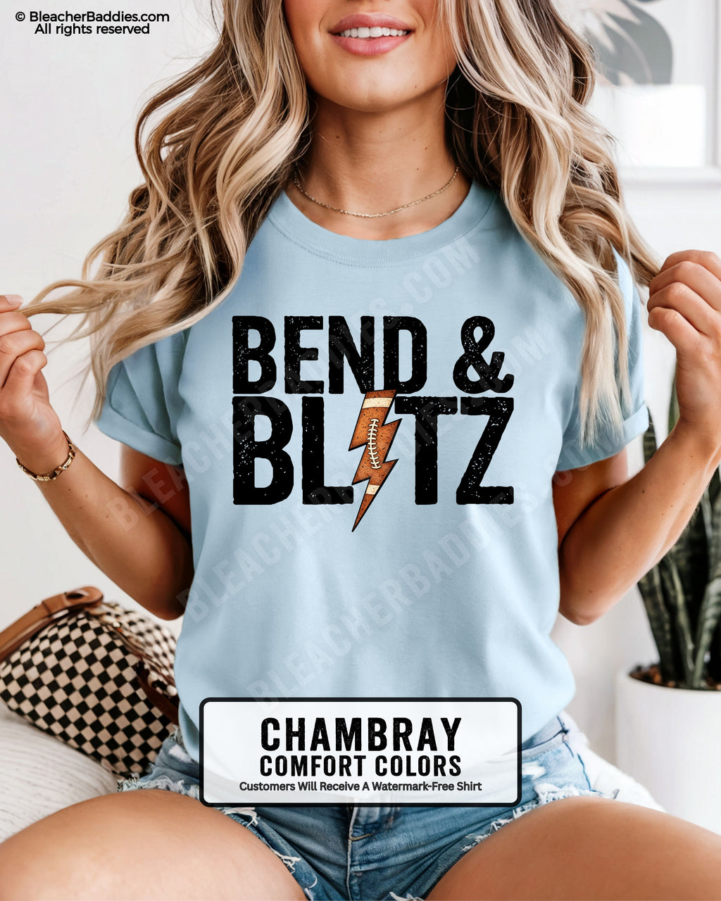 Front view of a chambray Comfort Colors t-shirt featuring the phrase "Bend & Blitz" in bold distressed lettering with a textured football lightning bolt graphic replacing the letter "I" for a trendy football game day design.