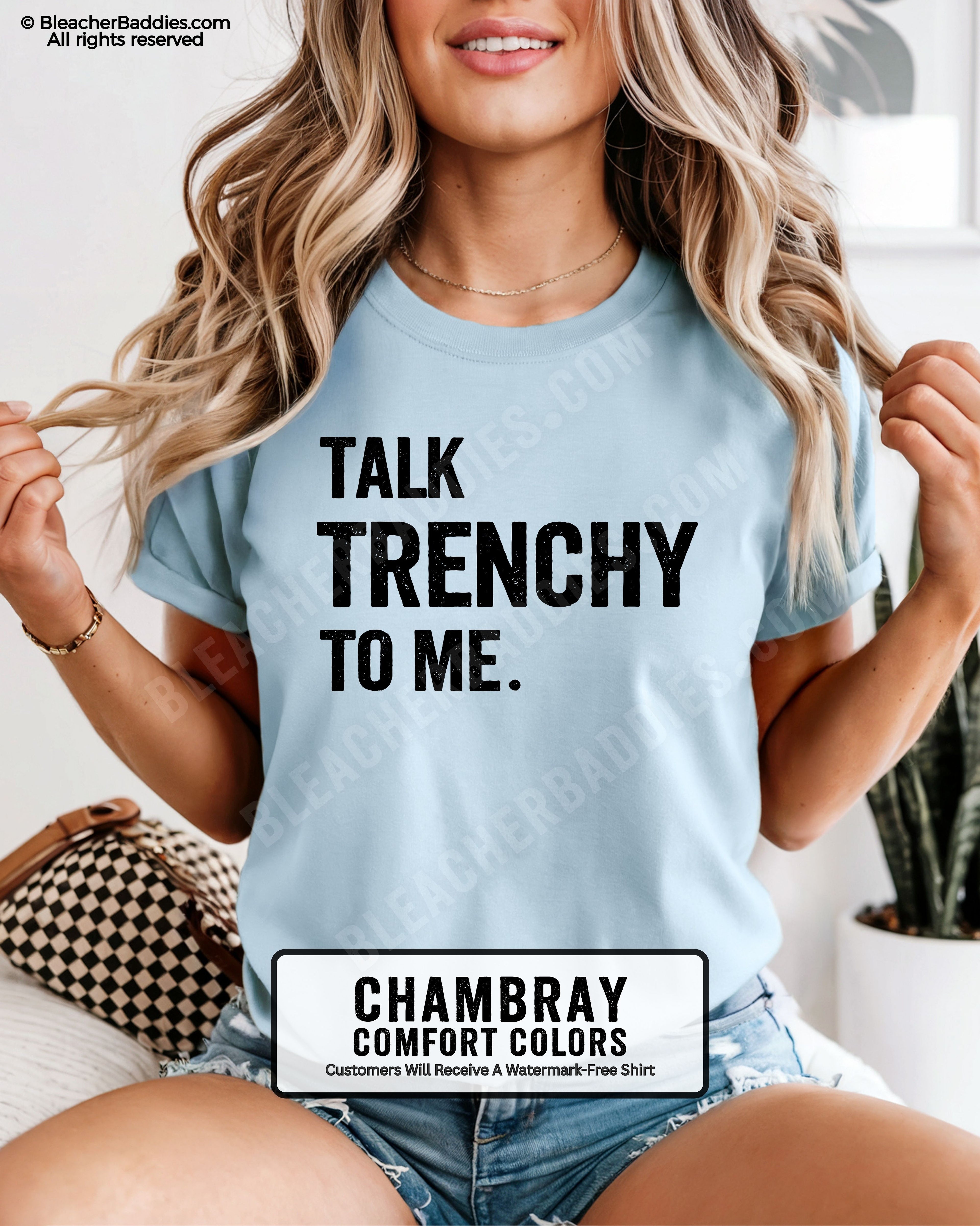 Model wearing Chambray Comfort Colors t-shirt featuring the phrase "Talk Trenchy To Me." in distressed lettering. Funny football lineman shirt for offensive line fans, football moms, game day, tailgates, and Friday night lights.