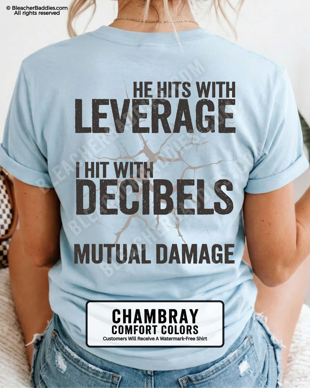 Back view of a chambray Comfort Colors football mom t-shirt featuring the "He Hits with Leverage, I Hit with Decibels" graphic and "Mutual Damage" printed in a distressed game day design.