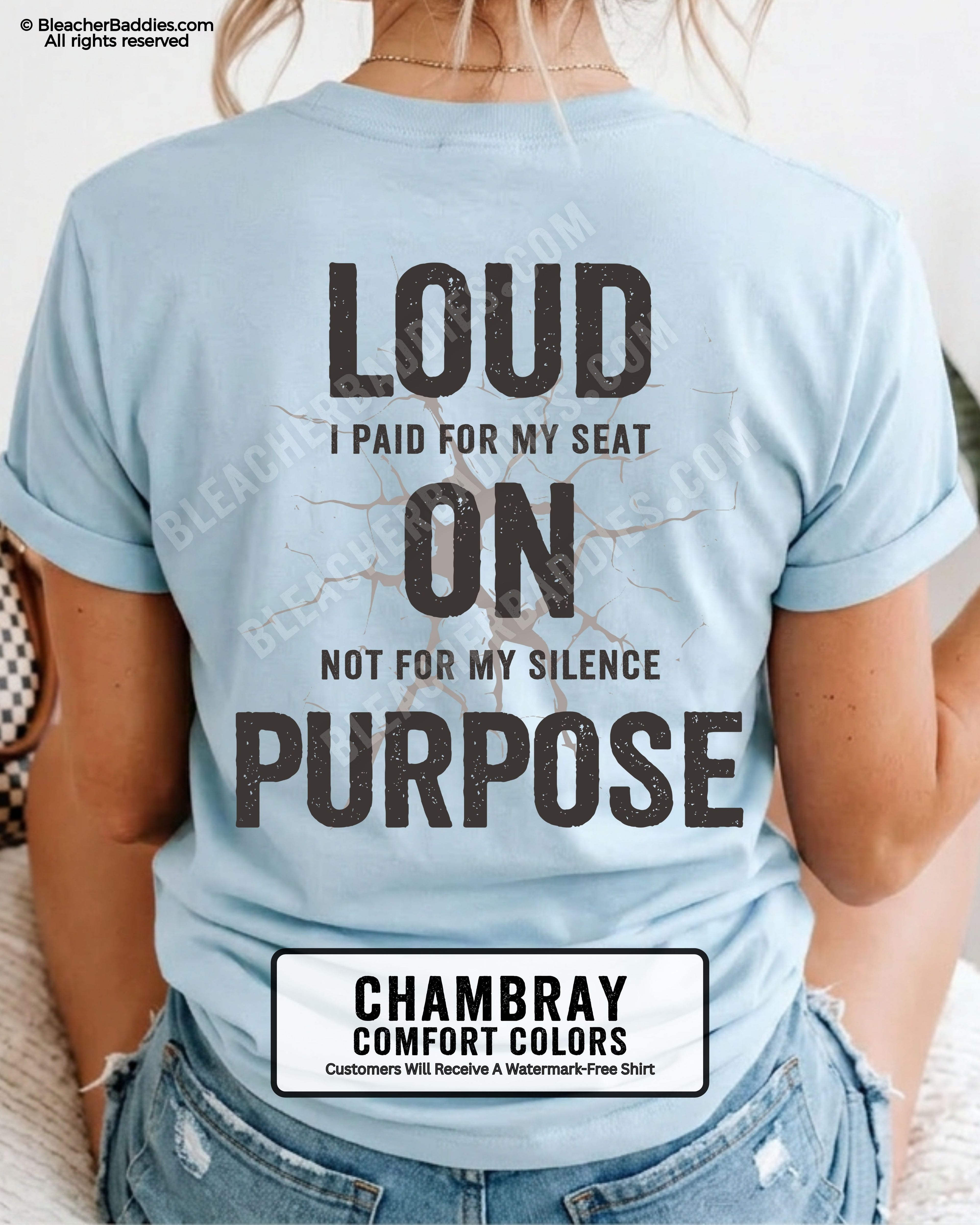 Woman wearing a CHAMBRAY Comfort Colors t-shirt shown from the back featuring a large distressed black graphic that reads “Loud I Paid for My Seat On Purpose Not For My Silence” with a cracked texture effect.