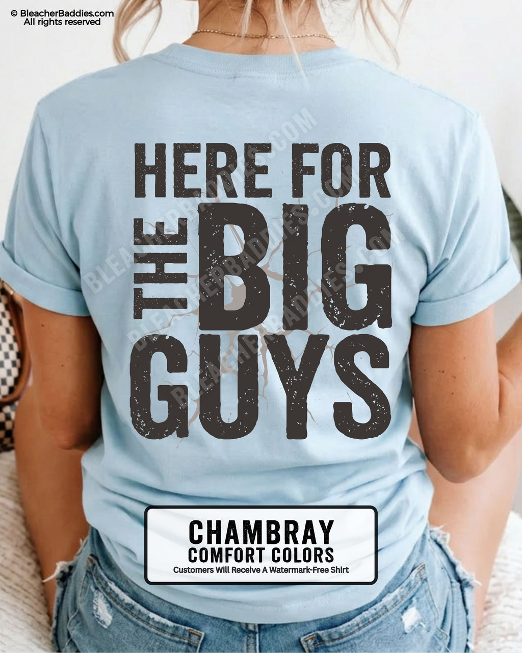 Close-up of football mom wearing a chambray comfort colors game day shirt showing distressed black text “Here for the big guys” with cracked effect graphic behind lettering