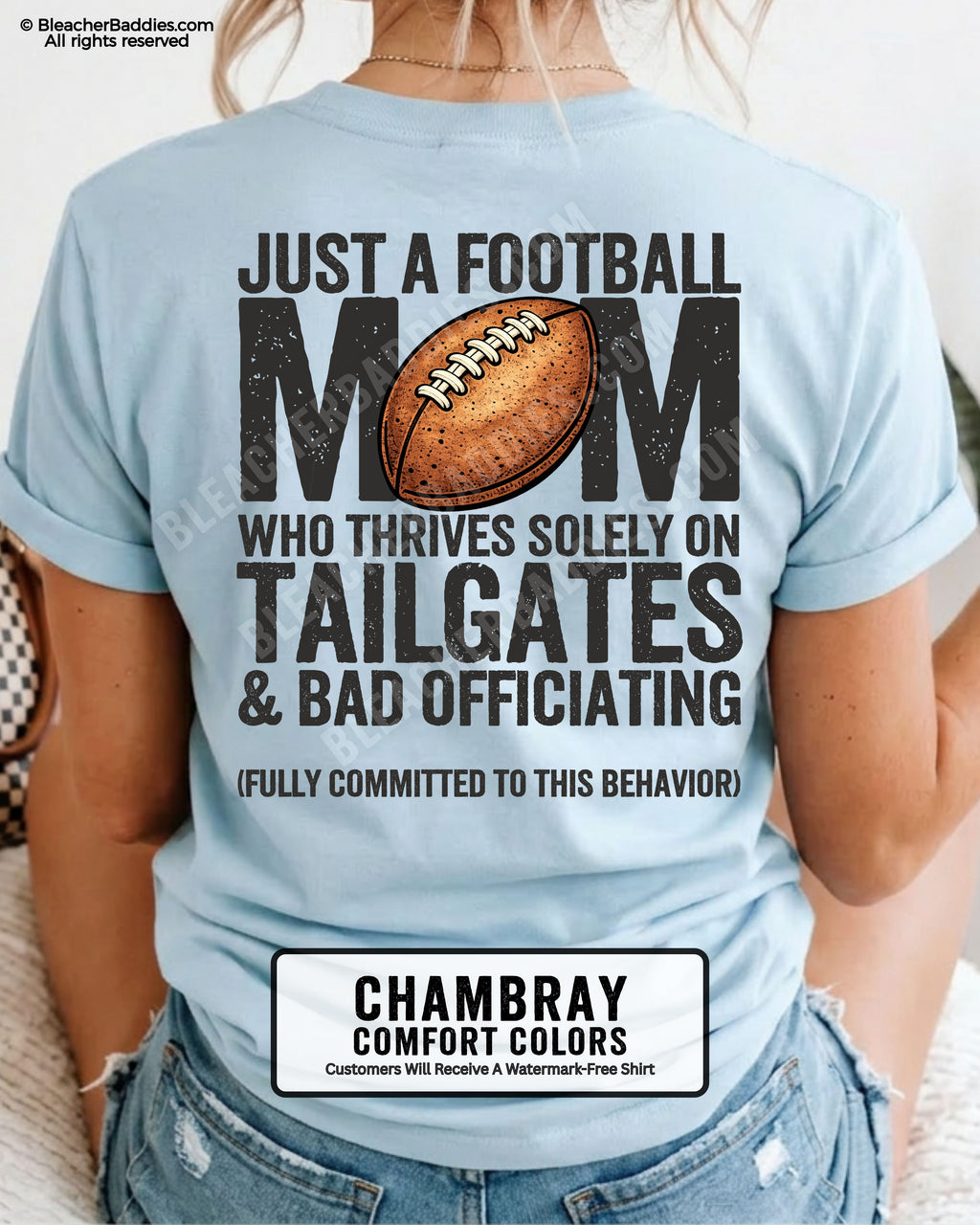 Football mom game day shirt worn by a model on a chambray Comfort Colors tee, featuring a back graphic that says, “Just a football mom who thrives solely on tailgates & bad officiating (fully committed to this behavior).”