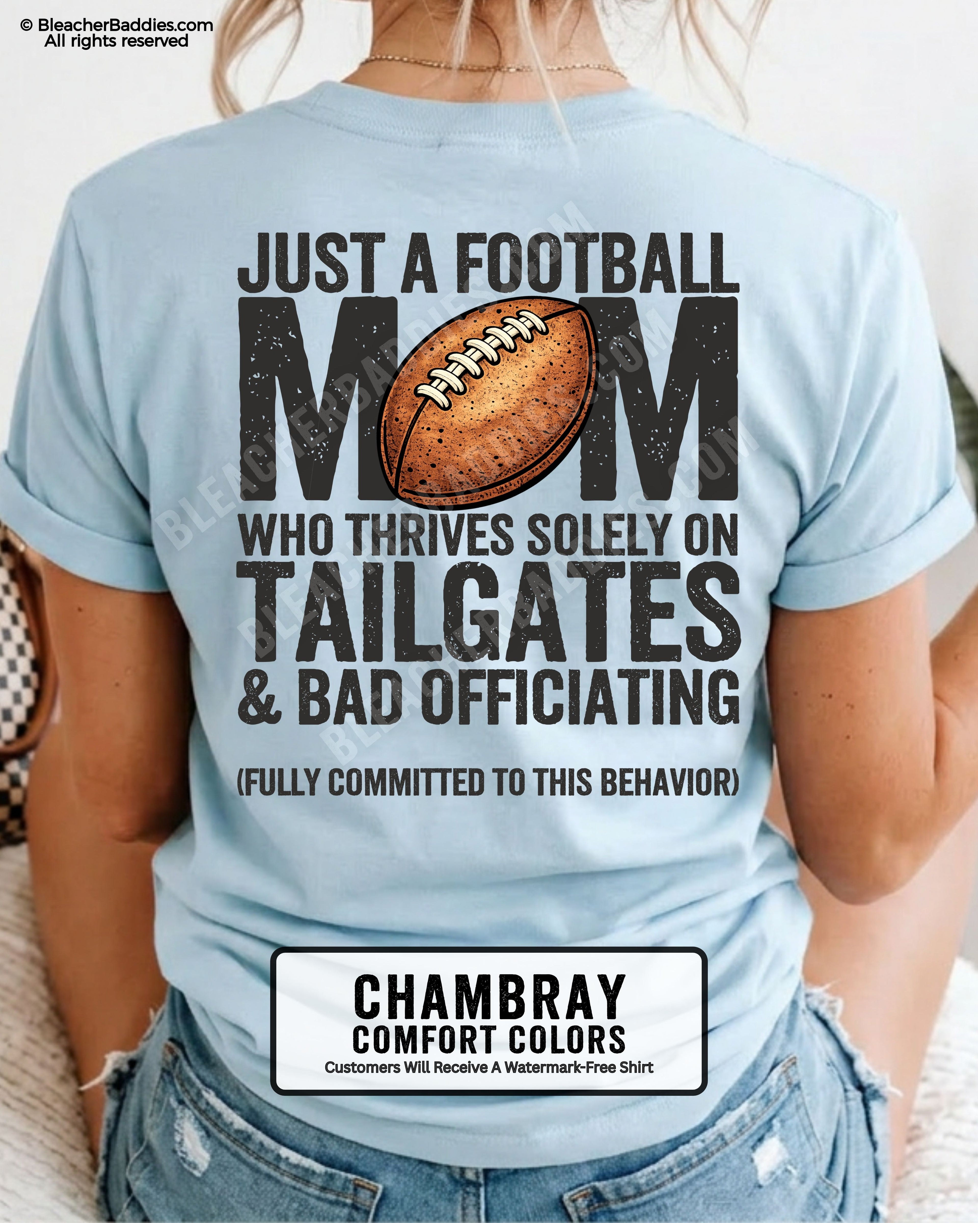 Football mom game day shirt worn by a model on a chambray Comfort Colors tee, featuring a back graphic that says, “Just a football mom who thrives solely on tailgates & bad officiating (fully committed to this behavior).”