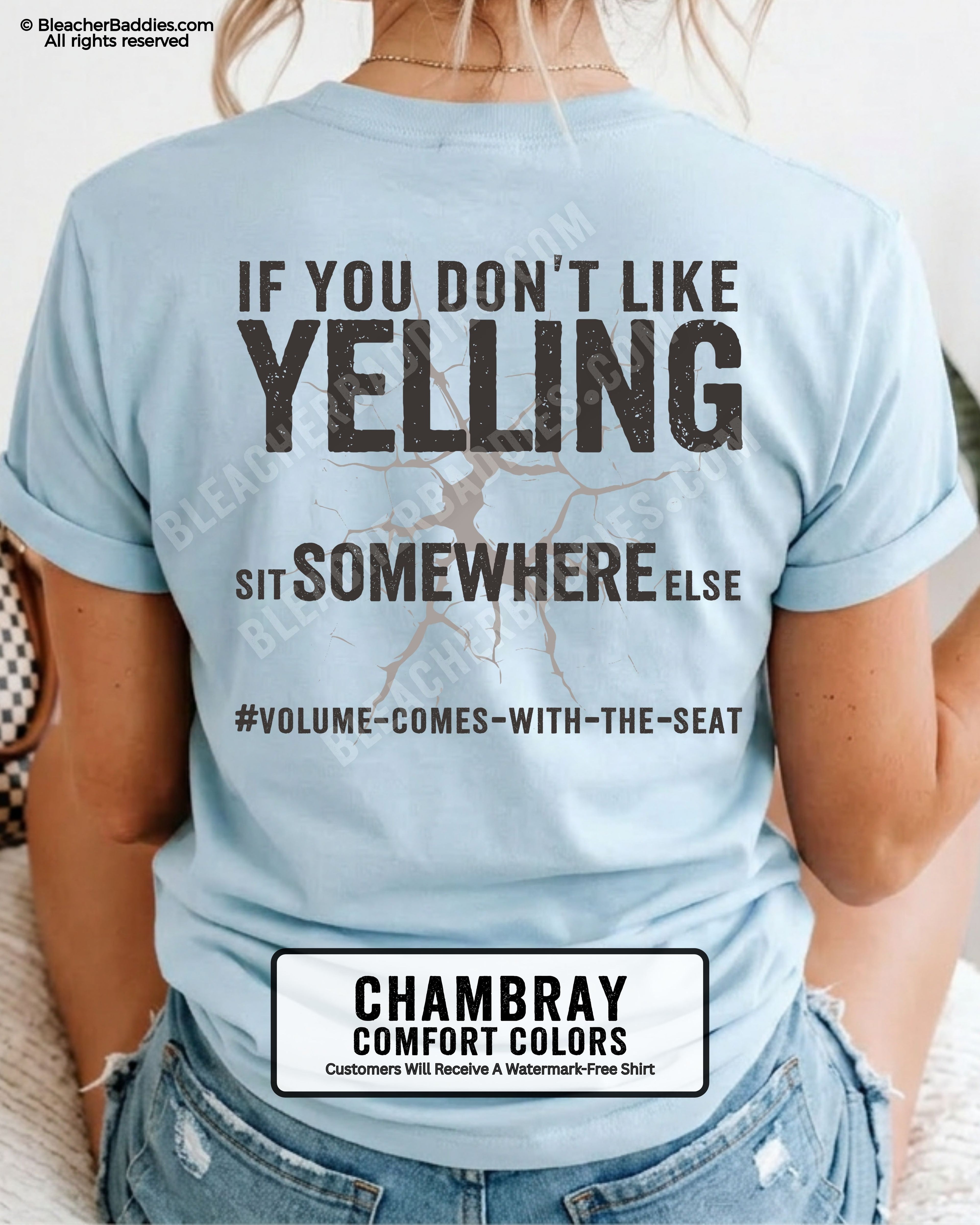 Woman wearing a chambray blue Comfort Colors t-shirt shown from the back featuring a large distressed black graphic that reads “If You Don’t Like Yelling Sit Somewhere Else #Volume Comes With the Seat.”