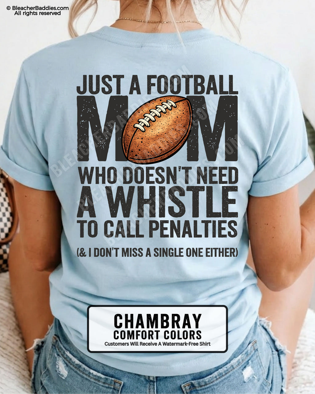 Football mom game day shirt on chambray Comfort Colors tee with bold back graphic that reads “Just a football mom who doesn’t need a whistle to call penalties and I don’t miss a single one either”