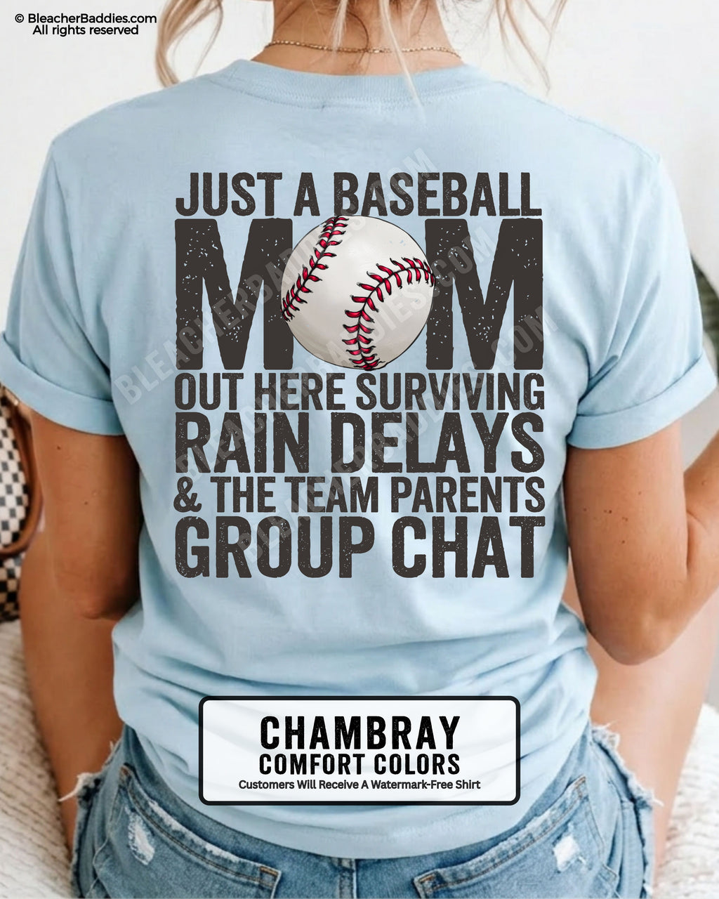 Chambray baseball mom graphic tee featuring distressed black back design reading “Just a baseball mom out here surviving rain delays and the team parents group chat” with baseball illustration centered in MOM