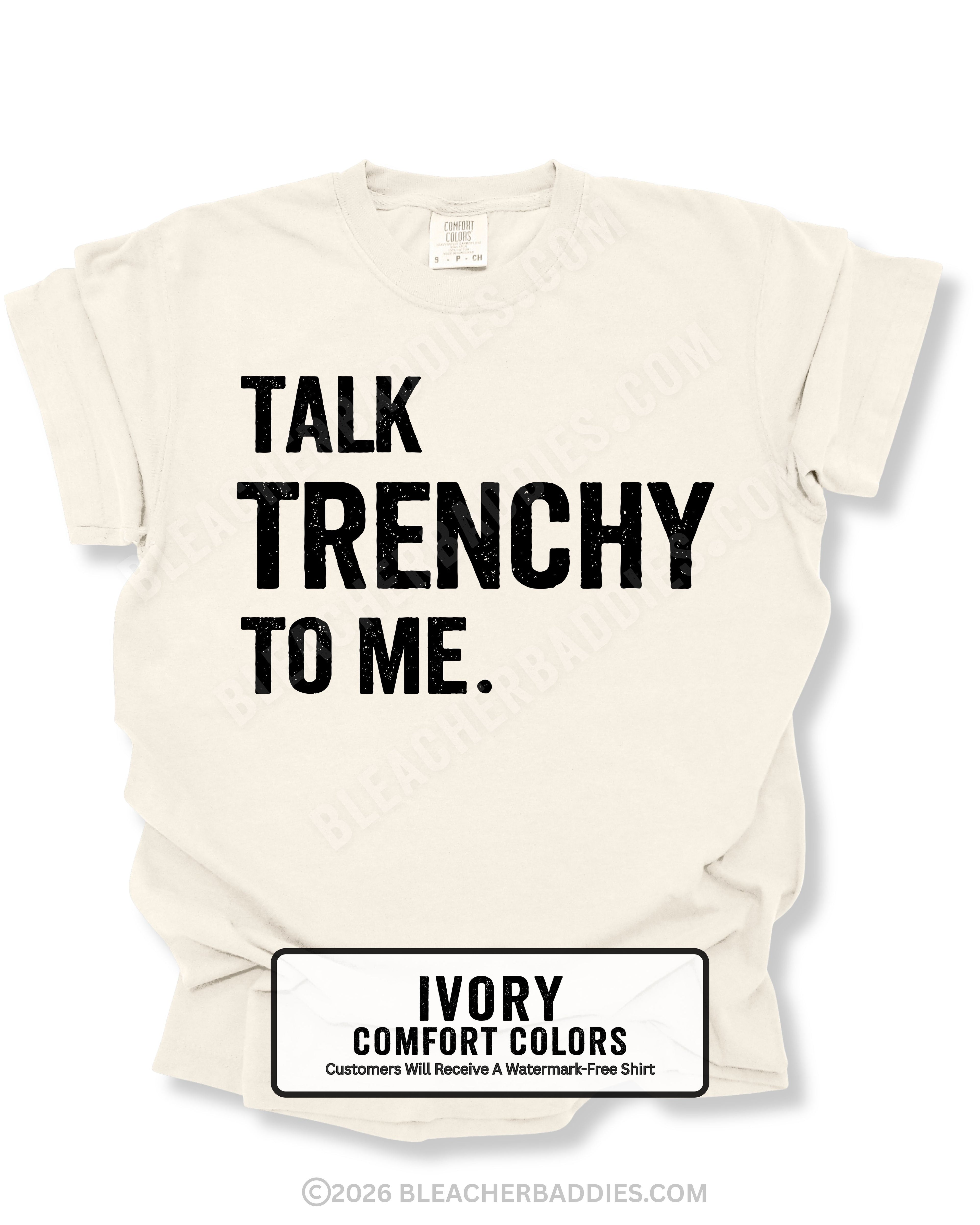 Flat lay of an ivory Comfort Colors t-shirt featuring the distressed black text "TALK TRENCHY TO ME." in large block letters. The shirt is displayed on a white background with rolled sleeves, showcasing a bold football offensive line-inspired graphic perfect for linemen, football players, coaches, and trench football fans.