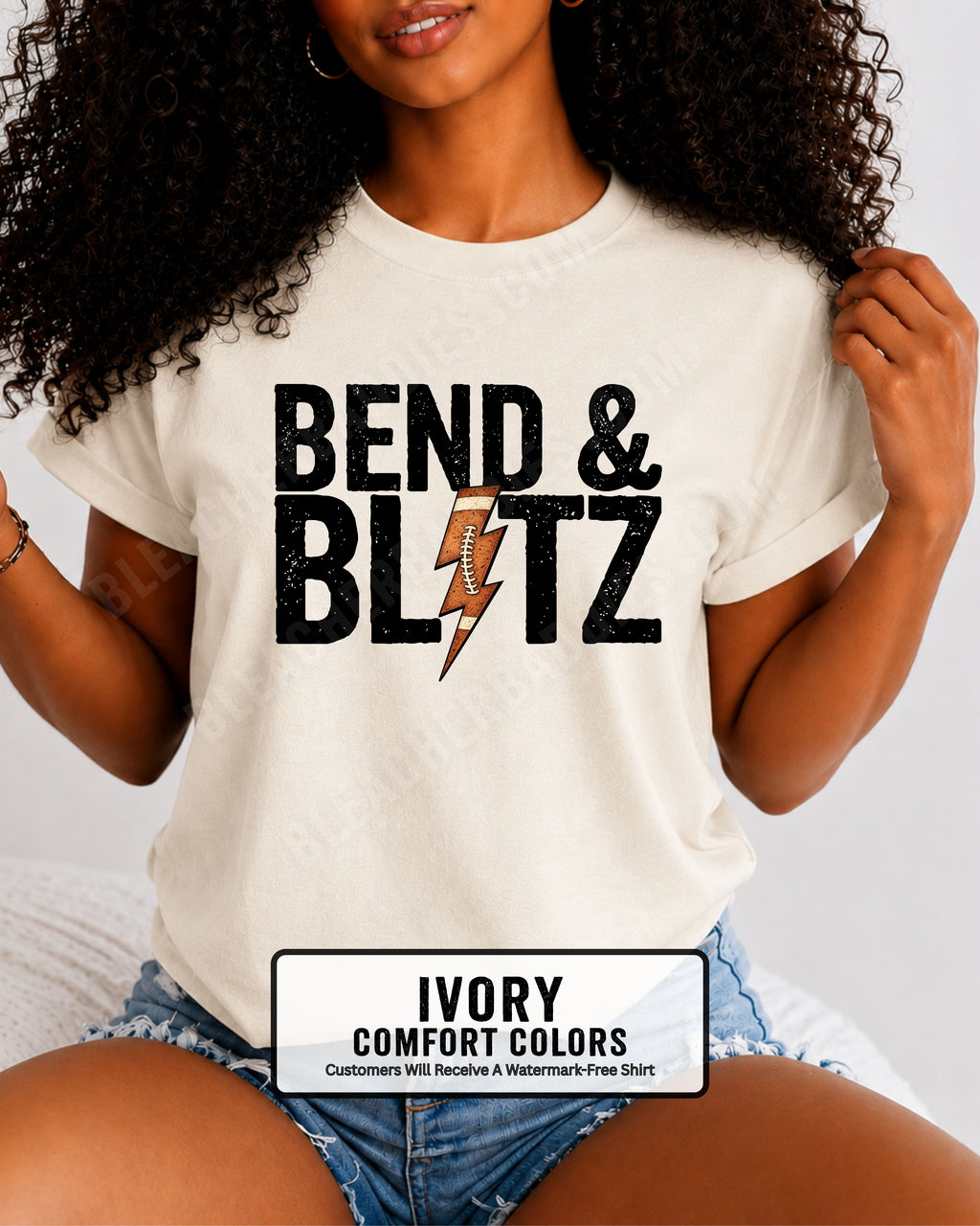 Close-up lifestyle photo of a woman wearing an ivory Comfort Colors t-shirt with the distressed black graphic "BEND & BLITZ" and a football lightning bolt design between the words. 