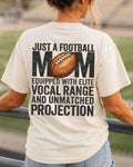 Football mom game day shirt worn by a model in a stadium, shown on an ivory Comfort Colors tee with a back graphic that says, “Just a football mom equipped with elite vocal range and unmatched projection.”