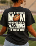 Football mom game day comfort colors black shirt worn in stadium stands with back graphic reading “Just a football mom who doesn’t do warnings & means what she said the first time”