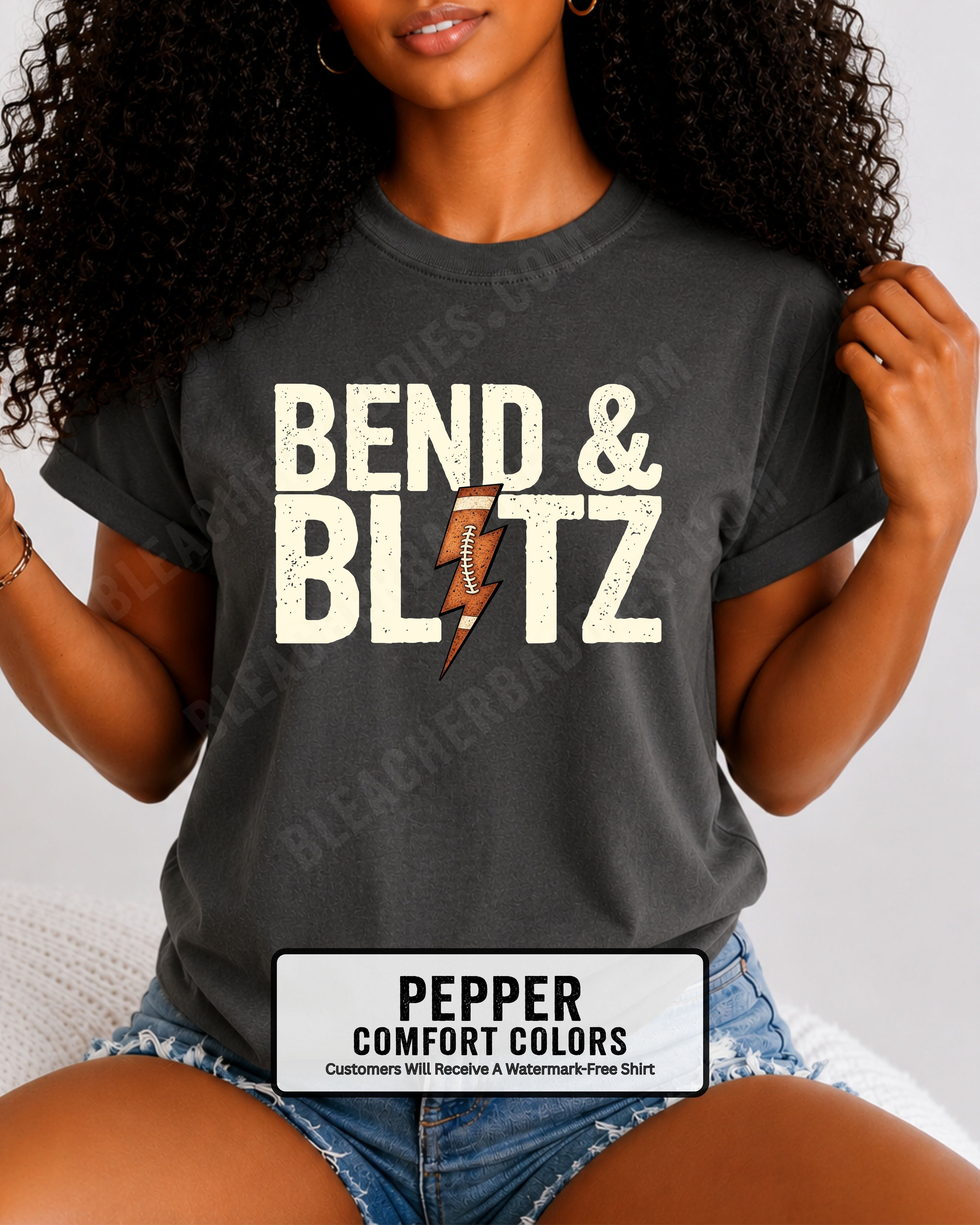 Close-up lifestyle photo of a football fan wearing a pepper Comfort Colors t-shirt with the distressed cream graphic "BEND & BLITZ" and a football lightning bolt design between the words. 