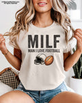IVORY Comfort Colors t-shirt featuring "MILF (Man I Love Football)" with a vintage football helmet and football graphic. Funny football fan shirt for moms, game day, tailgates, and Friday night lights.
