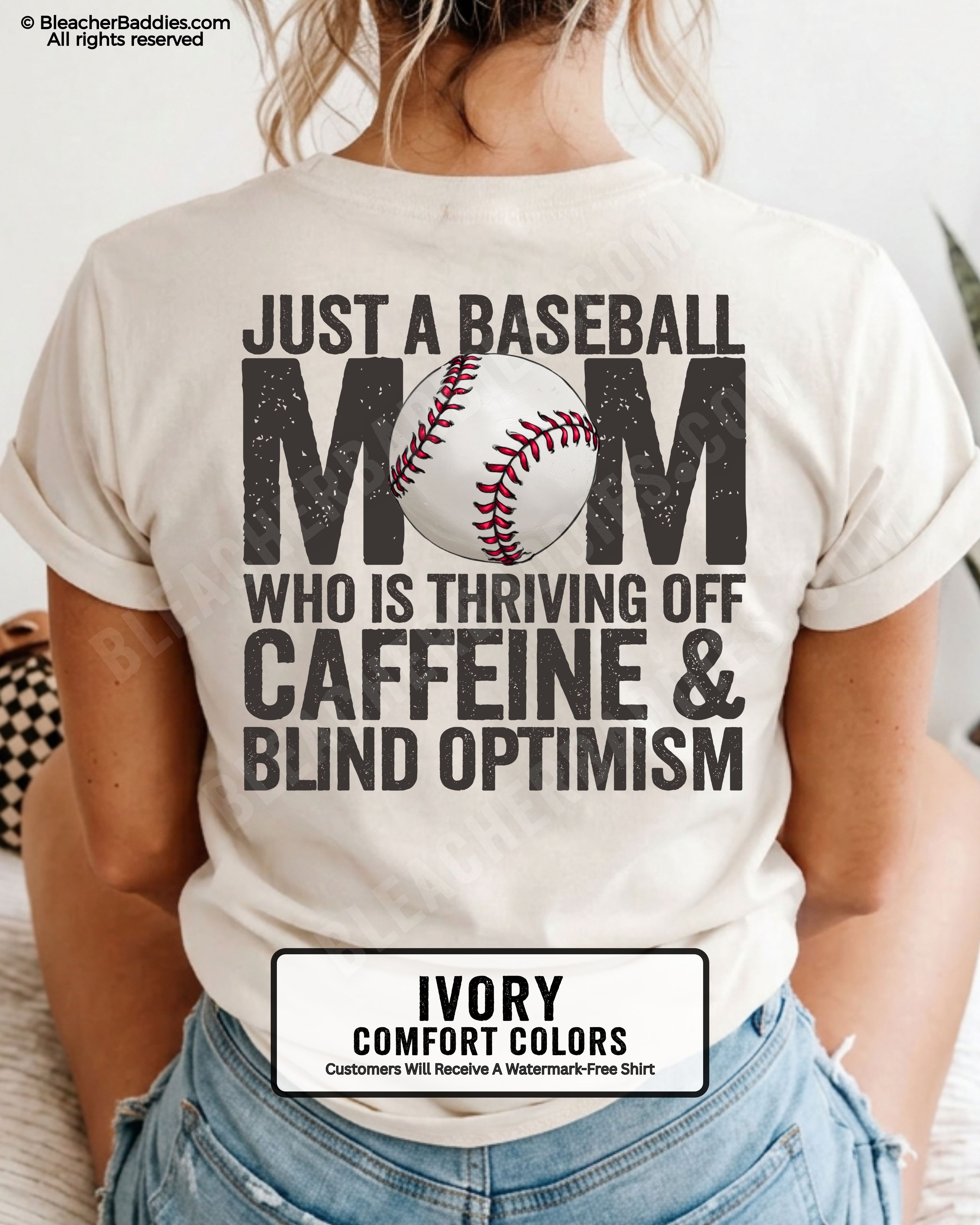 Ivory baseball mom game day shirt with distressed black back graphic reading “Just a baseball mom who is thriving off caffeine and blind optimism” with baseball illustration replacing the O in MOM
