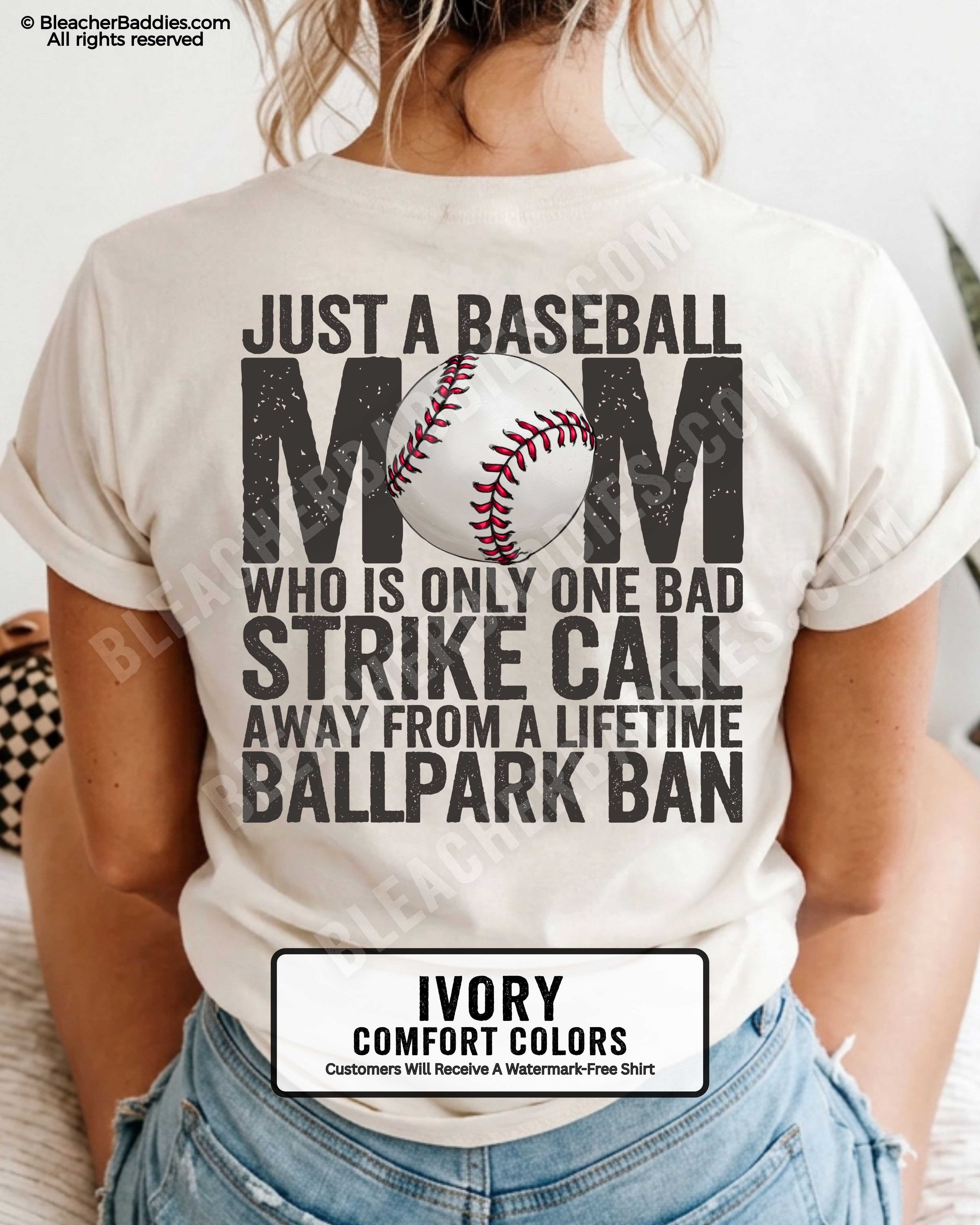 Ivory Comfort Colors game day shirt worn by woman showing distressed back graphic reading “Just a Baseball Mom Who Is Only One Bad Strike Call Away From A Lifetime Ballpark Ban” with baseball illustration layered over MOM  text