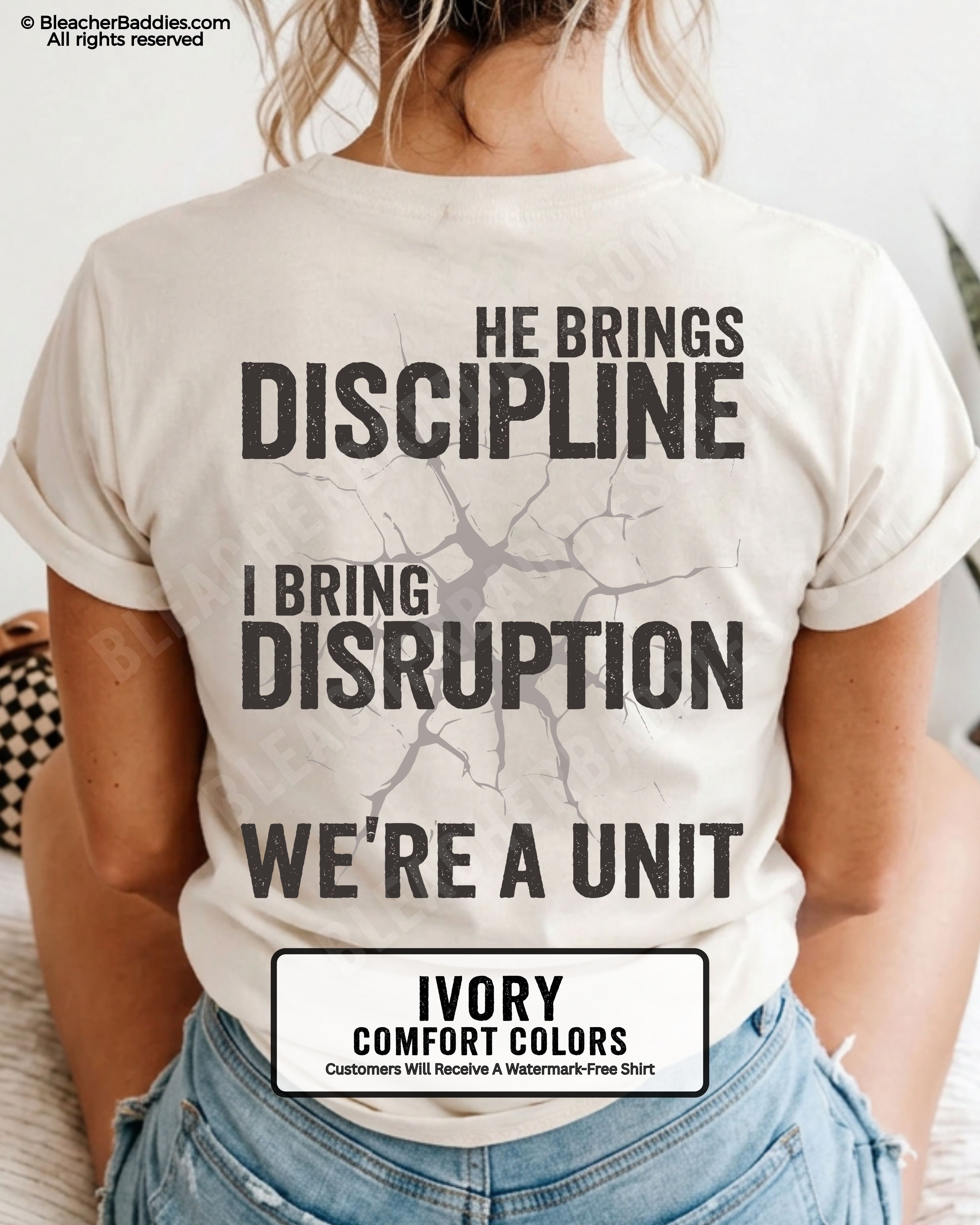 Back view of IVORY Comfort Colors football mom game day shirt featuring “He Brings Discipline I Bring Disruption We’re a Unit” design worn by woman indoors with denim shorts