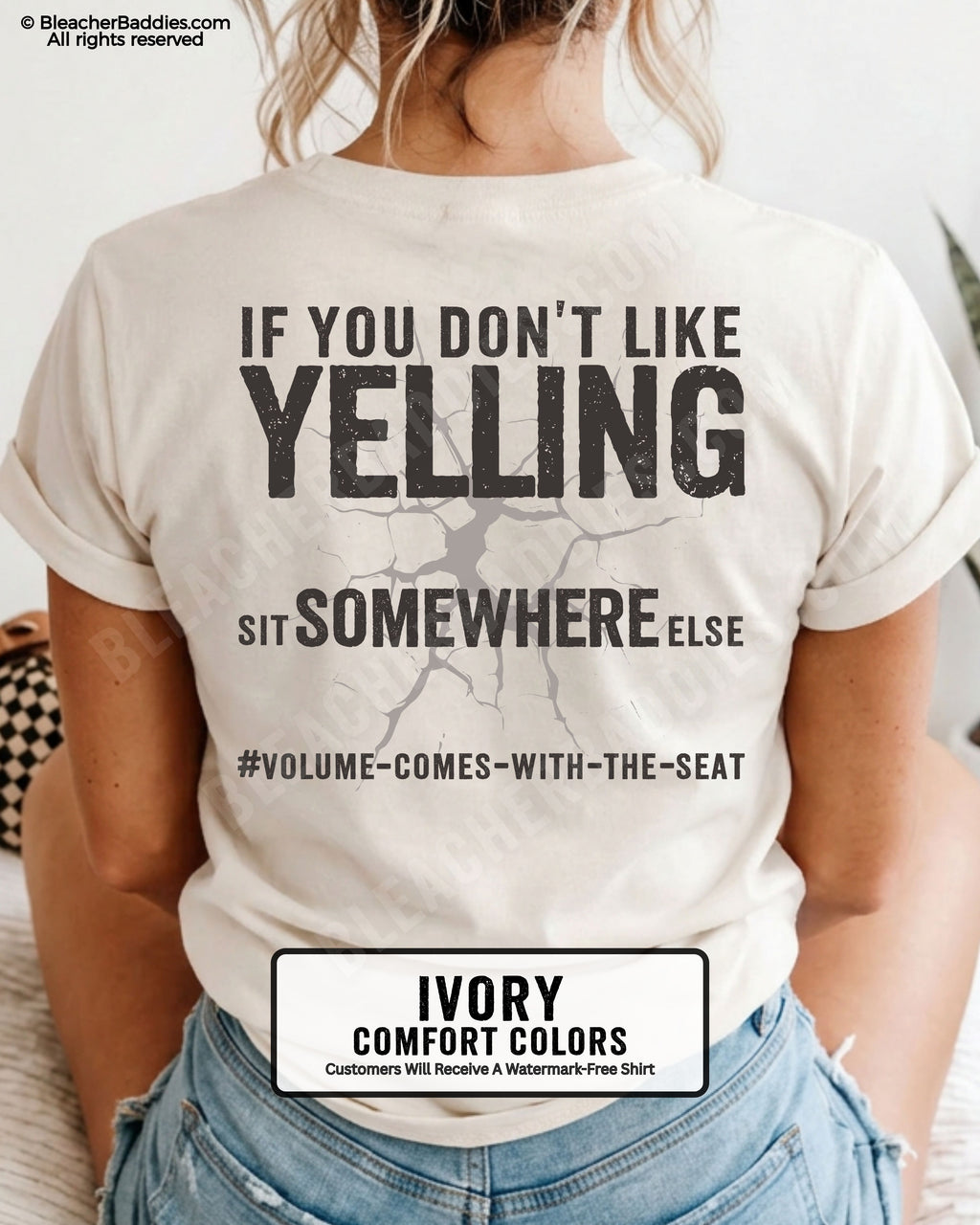 Woman wearing an ivory Comfort Colors t-shirt shown from the back featuring a large distressed black graphic that reads “If You Don’t Like Yelling Sit Somewhere Else #Volume Comes With the Seat.”