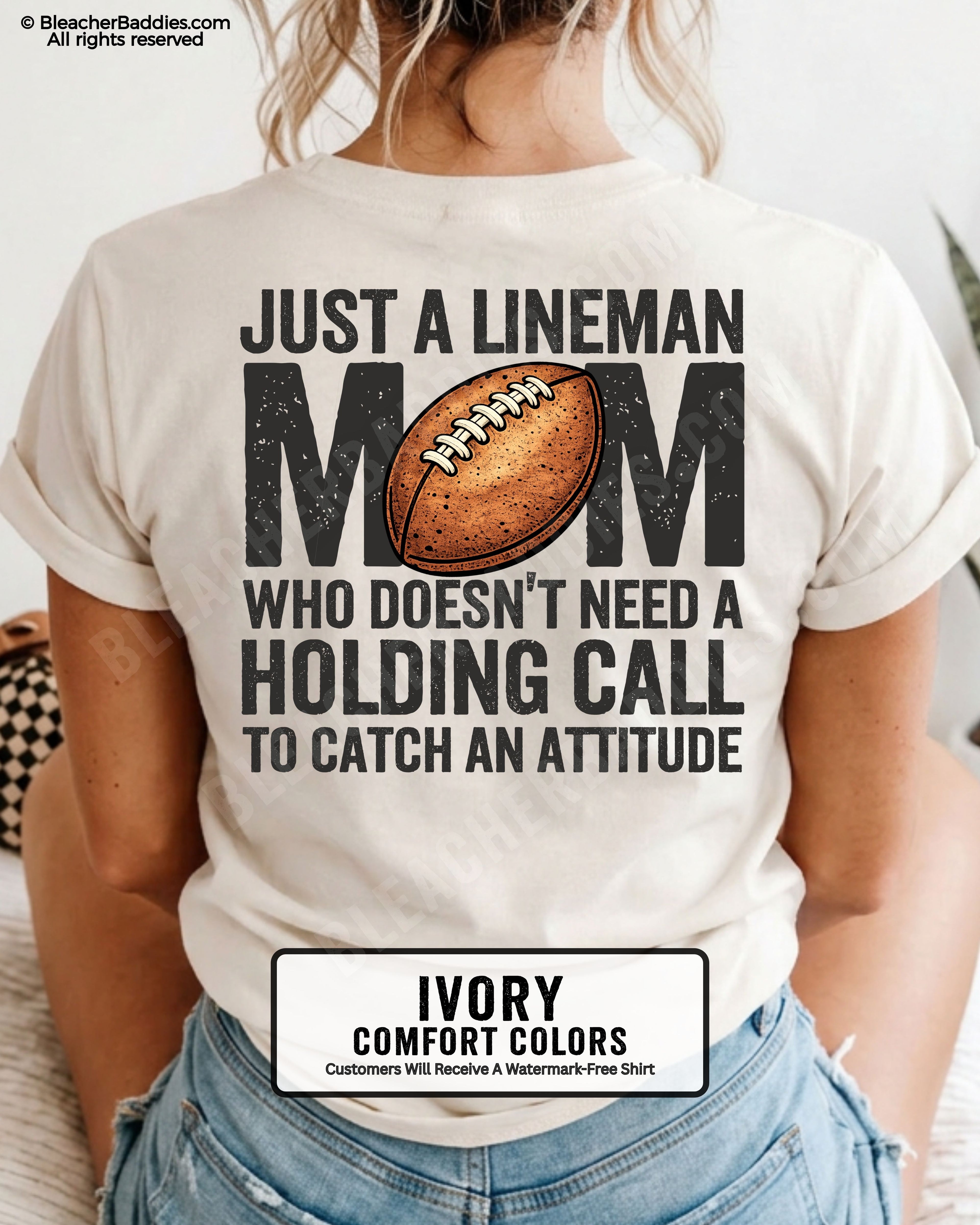 back view of woman wearing an ivory Comfort Colors lineman mom football shirt featuring bold back design that says “Just a lineman mom who doesn’t need a holding call to catch an attitude”