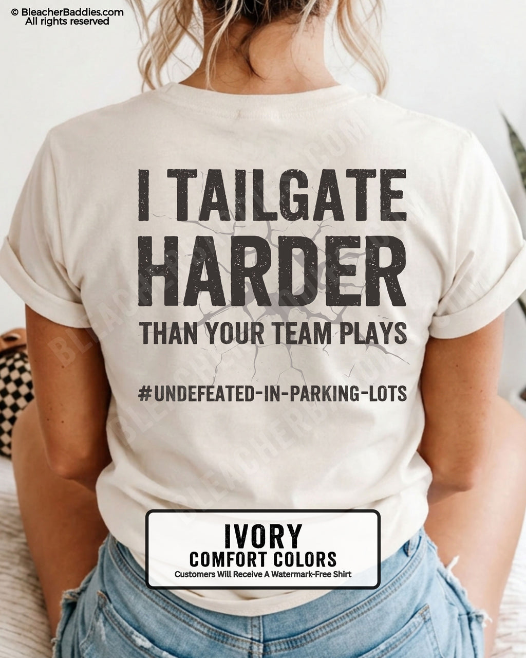 Woman wearing IVORY Comfort Colors football mom game day shirt with back design that reads “I tailgate harder than your team plays #undefeated-in-parking-lots” in distressed black text with cracked graphic and chambray color label shown