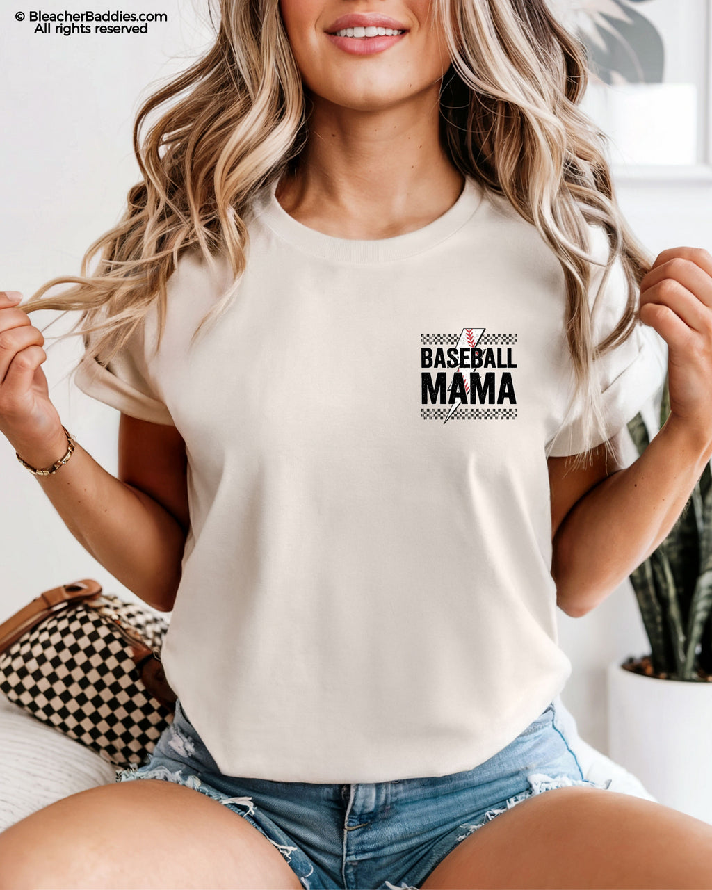 Ivory Comfort Colors baseball mom shirt with distressed black checkerboard stripes and a mini “Baseball Mama” graphic featuring red baseball stitching and bold grunge lettering on the chest pocket area.