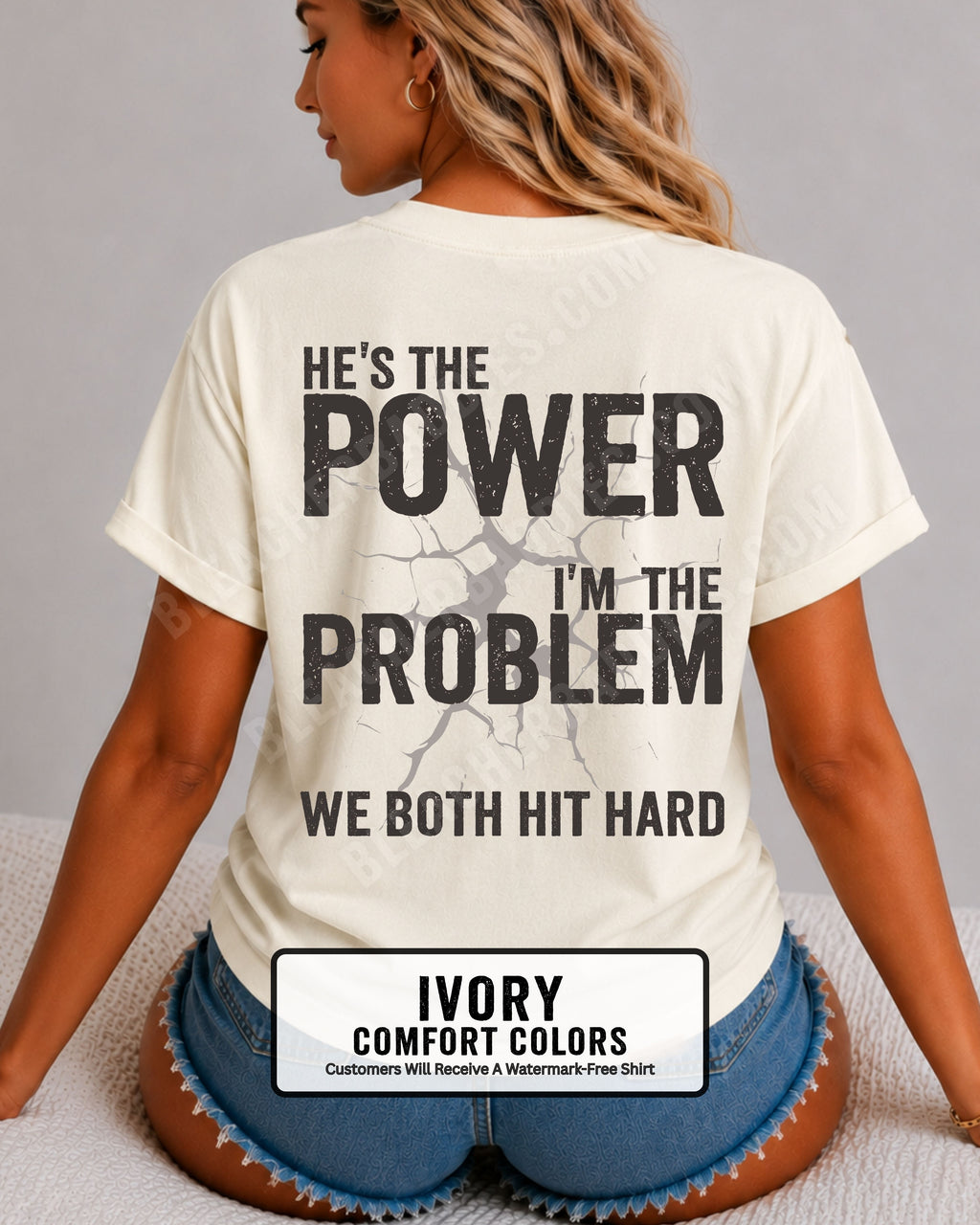 Back view of ivory Comfort Colors football mom game day shirt reading “He’s the Power I’m the Problem We Both Hit Hard,” close-up fit on woman wearing denim shorts