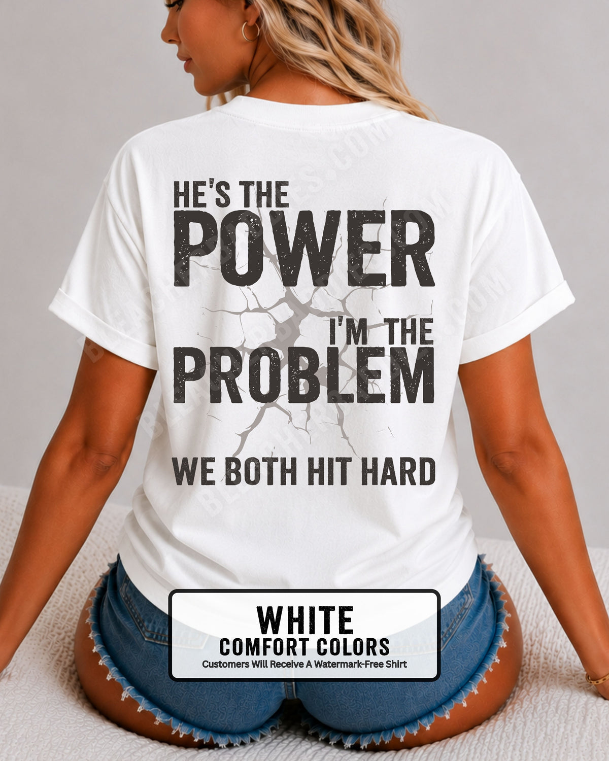 Back view of white Comfort Colors football mom game day shirt reading “He’s the Power I’m the Problem We Both Hit Hard,” close-up fit on woman wearing denim shorts