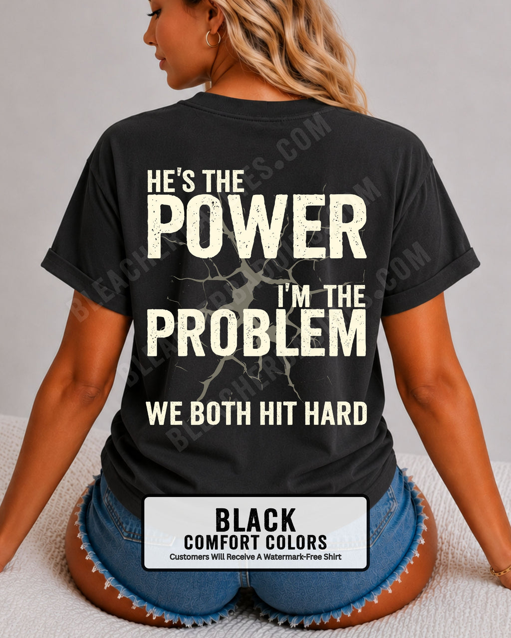 Back view of black Comfort Colors football mom game day shirt reading “He’s the Power I’m the Problem We Both Hit Hard,” close-up fit on woman wearing denim shorts