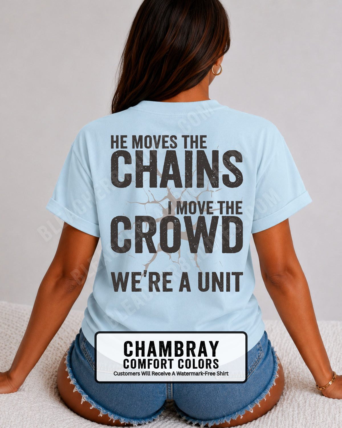 Back view of woman wearing chambray blue Comfort Colors football mom game day shirt featuring “He Moves the Chains I Move the Crowd We’re a Unit” bold graphic design