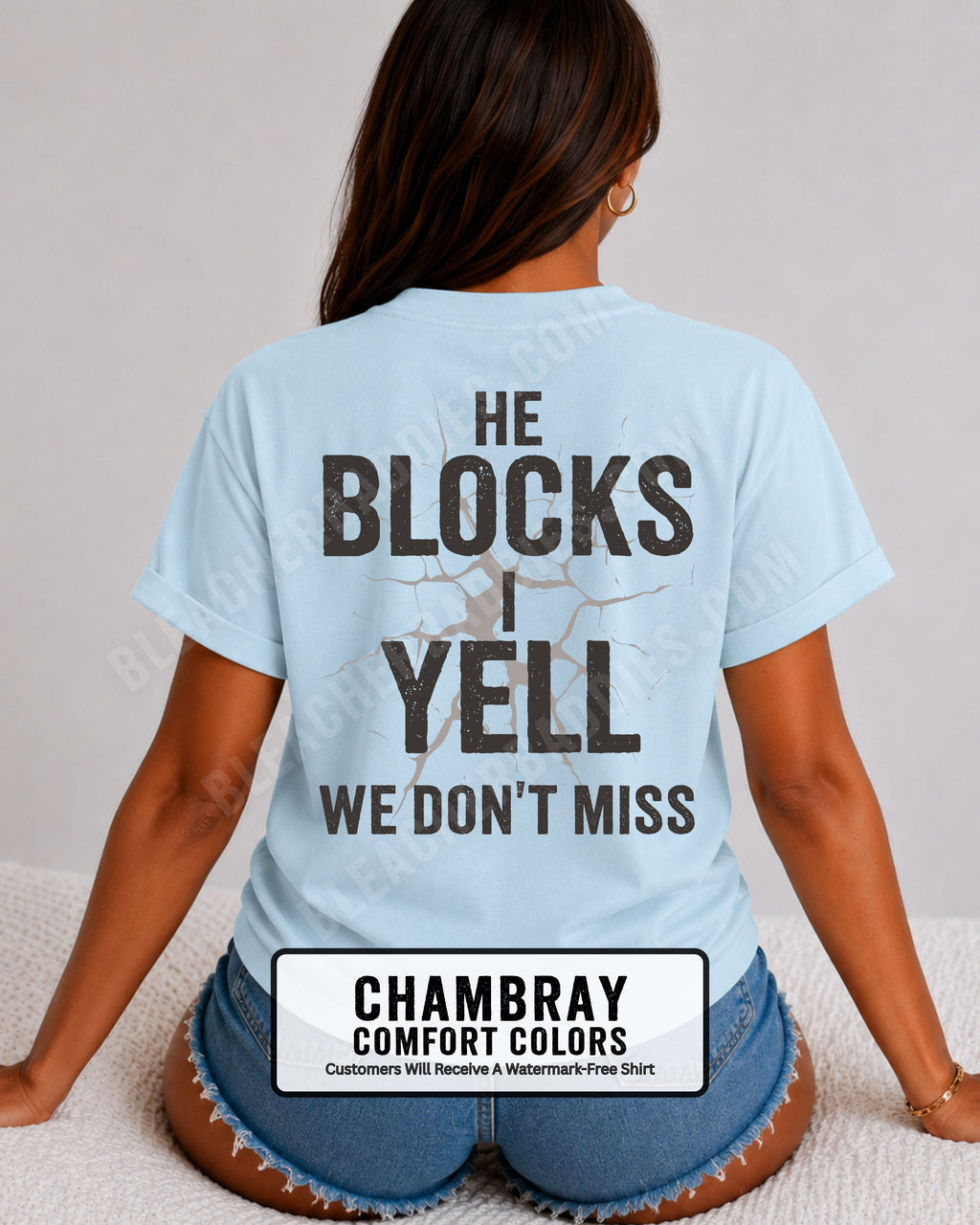 Woman wearing chambray blue Comfort Colors football mom game day shirt with back design that reads “He blocks I yell we don’t miss” in distressed black text with cracked graphic