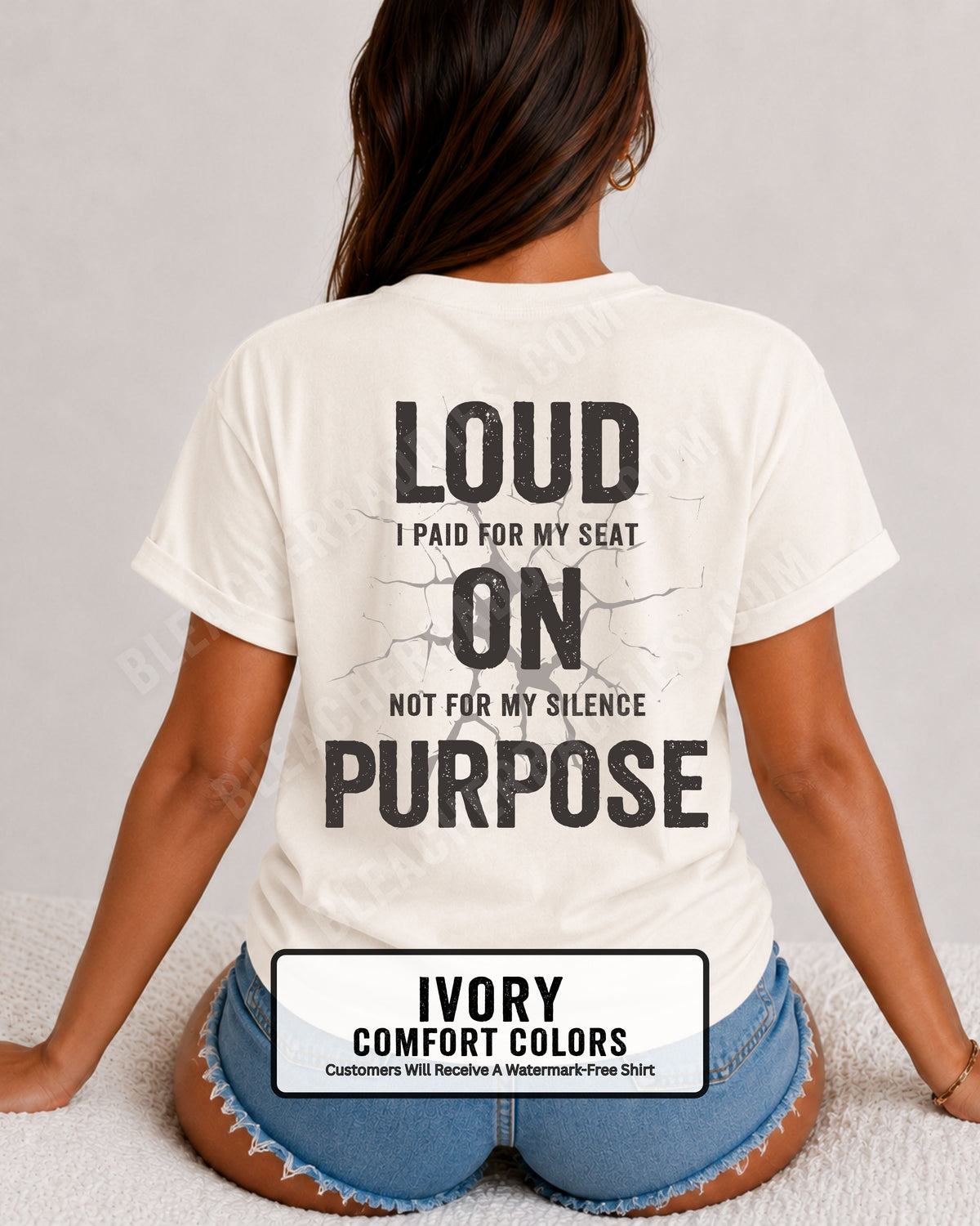 Woman wearing an ivory Comfort Colors t-shirt shown from the back featuring a large distressed black graphic that reads “Loud I Paid for My Seat On Purpose Not For My Silence” with a cracked texture effect.