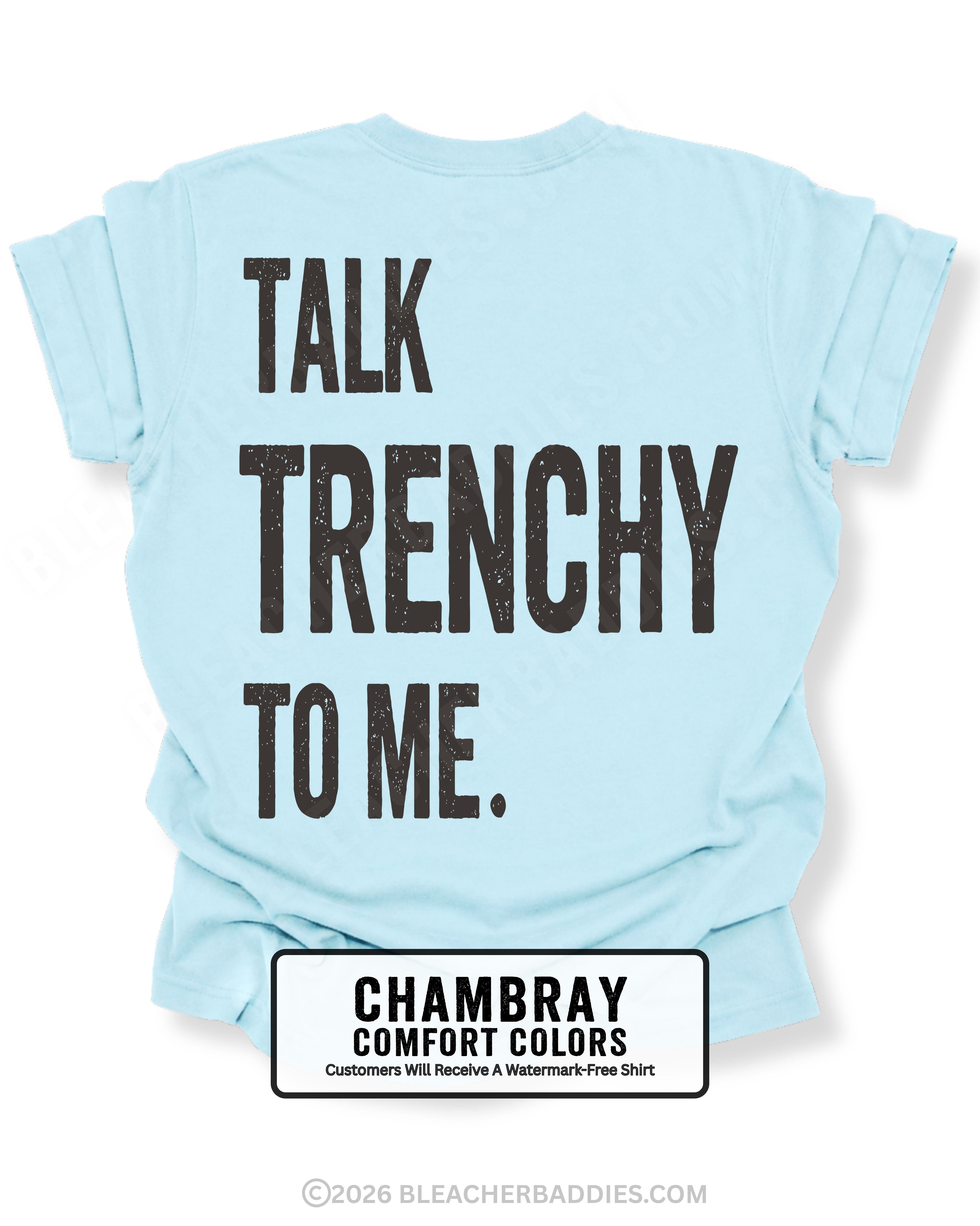 Chambray blue Comfort Colors T-shirt featuring the funny football back design "Talk Trenchy to Me" in distressed black lettering. Flat lay mockup showcasing a humorous offensive line fan shirt perfect for football moms, dads, tailgates, Friday night lights, and game day.