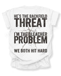 Back view of white Comfort Colors football mom game day shirt featuring “He’s the Backfield Threat I’m the Bleacher Problem We Both Hit Hard” bold graphic design. Linebacker mom shirt. Defensive Lineman Mom Shirt. Football mom shirt.