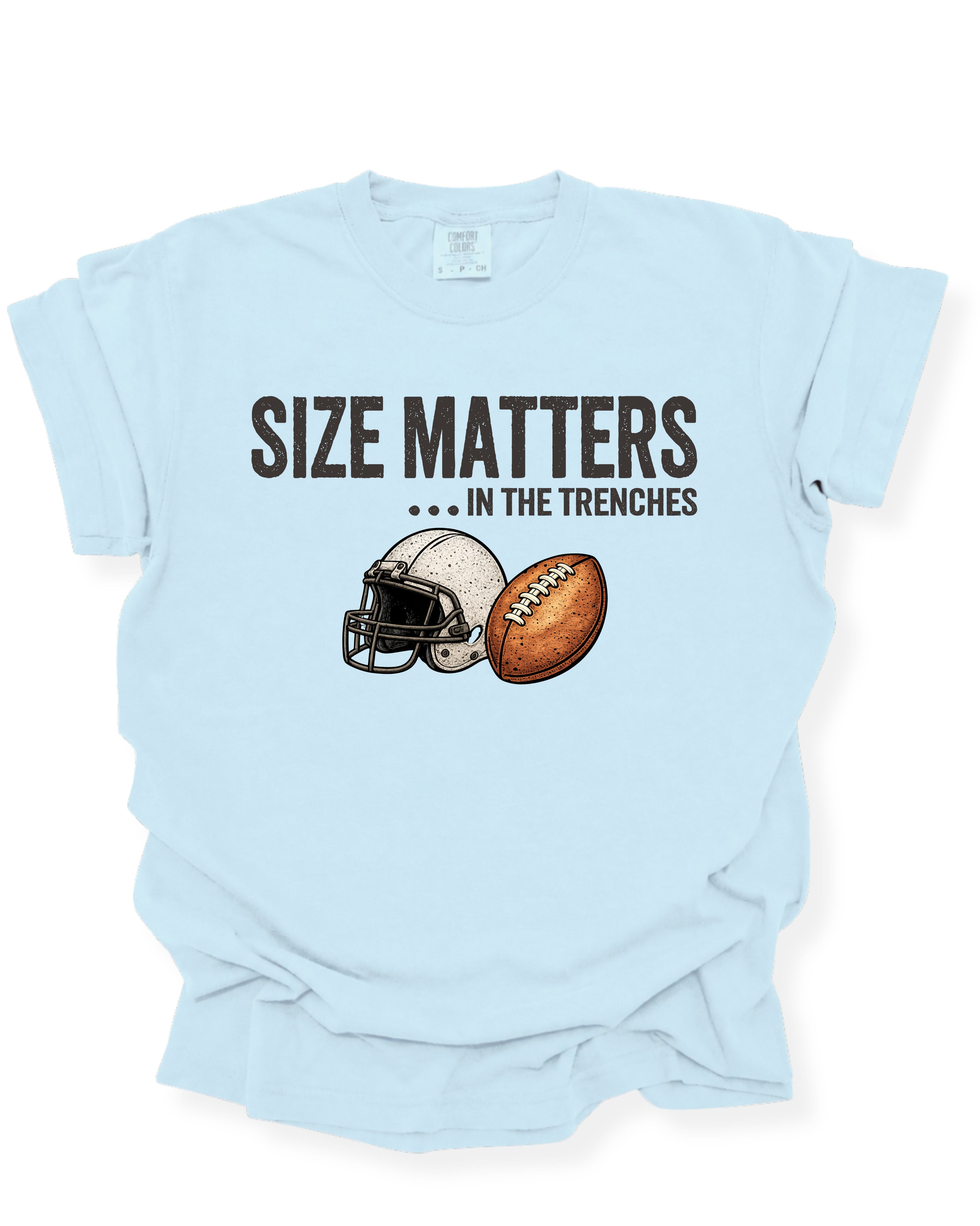 Flat lay mockup of a chambray blue Comfort Colors t-shirt featuring the funny football saying "Size Matters... In the Trenches" with a vintage football helmet and football graphic. Perfect game day shirt for football fans, offensive linemen, lineman moms, football moms, coaches, players, and anyone who knows games are won in the trenches.