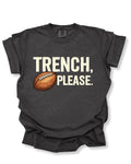 Flat lay mockup of a pepper Comfort Colors t-shirt featuring the funny football saying "Trench, Please." in distressed cream lettering with a vintage football graphic. A humorous game day shirt for football fans, offensive line supporters, linemen, coaches, football moms, and anyone who knows the trenches are where games are won.