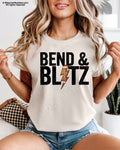 Front view of an ivory Comfort Colors t-shirt featuring the phrase "Bend & Blitz" in bold distressed lettering with a textured football lightning bolt graphic replacing the letter "I" for a trendy football game day design.