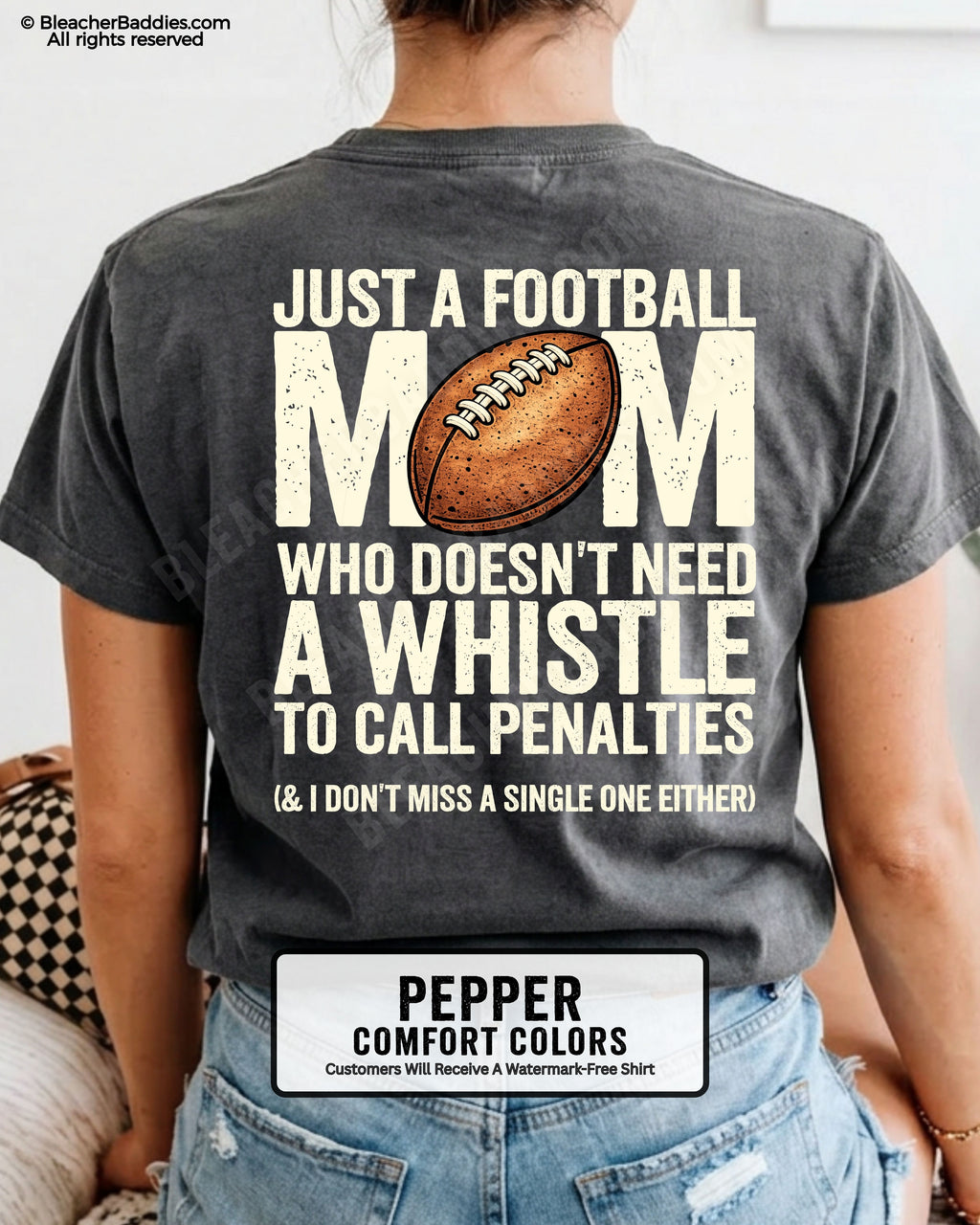 Football mom game day shirt on pepper Comfort Colors tee with bold back graphic that reads “Just a football mom who doesn’t need a whistle to call penalties and I don’t miss a single one either”